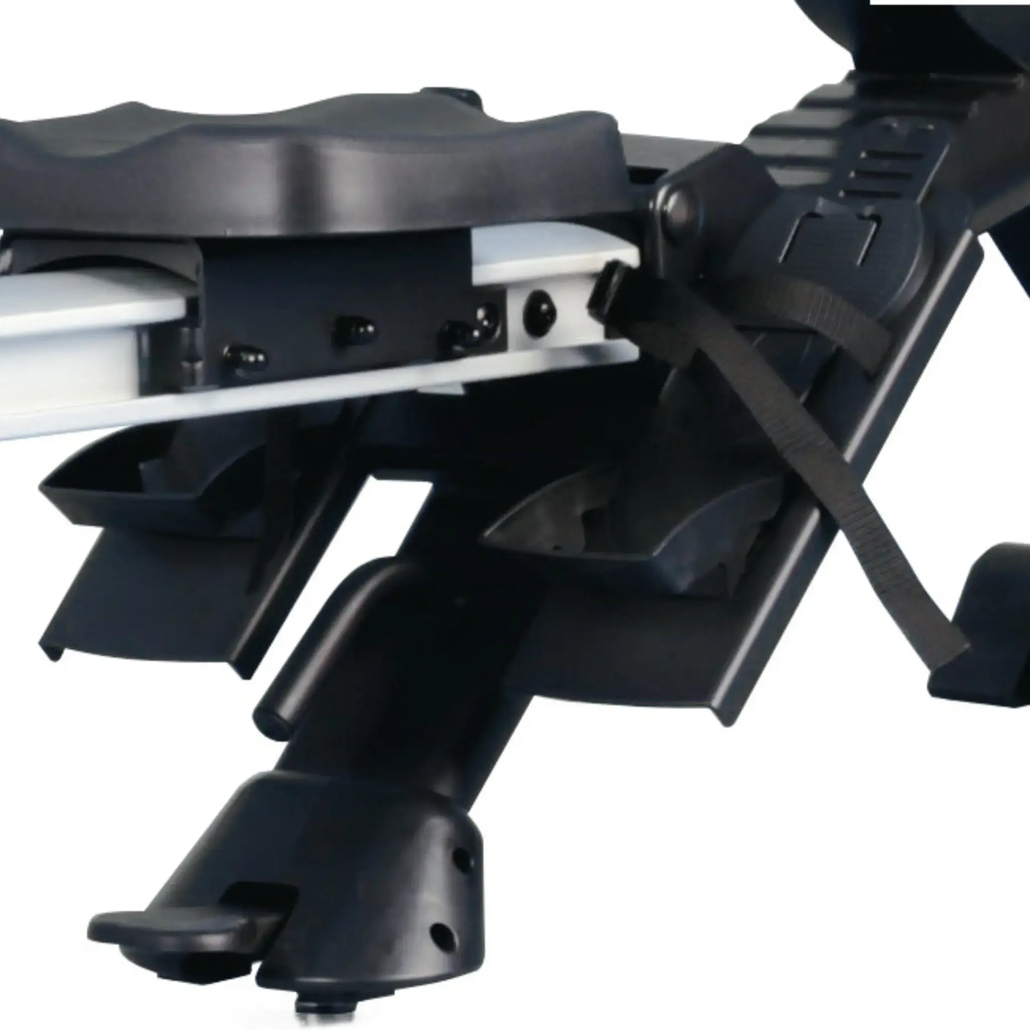 A close-up of a car roof rack, with black plastic components and straps, showing mounting details.