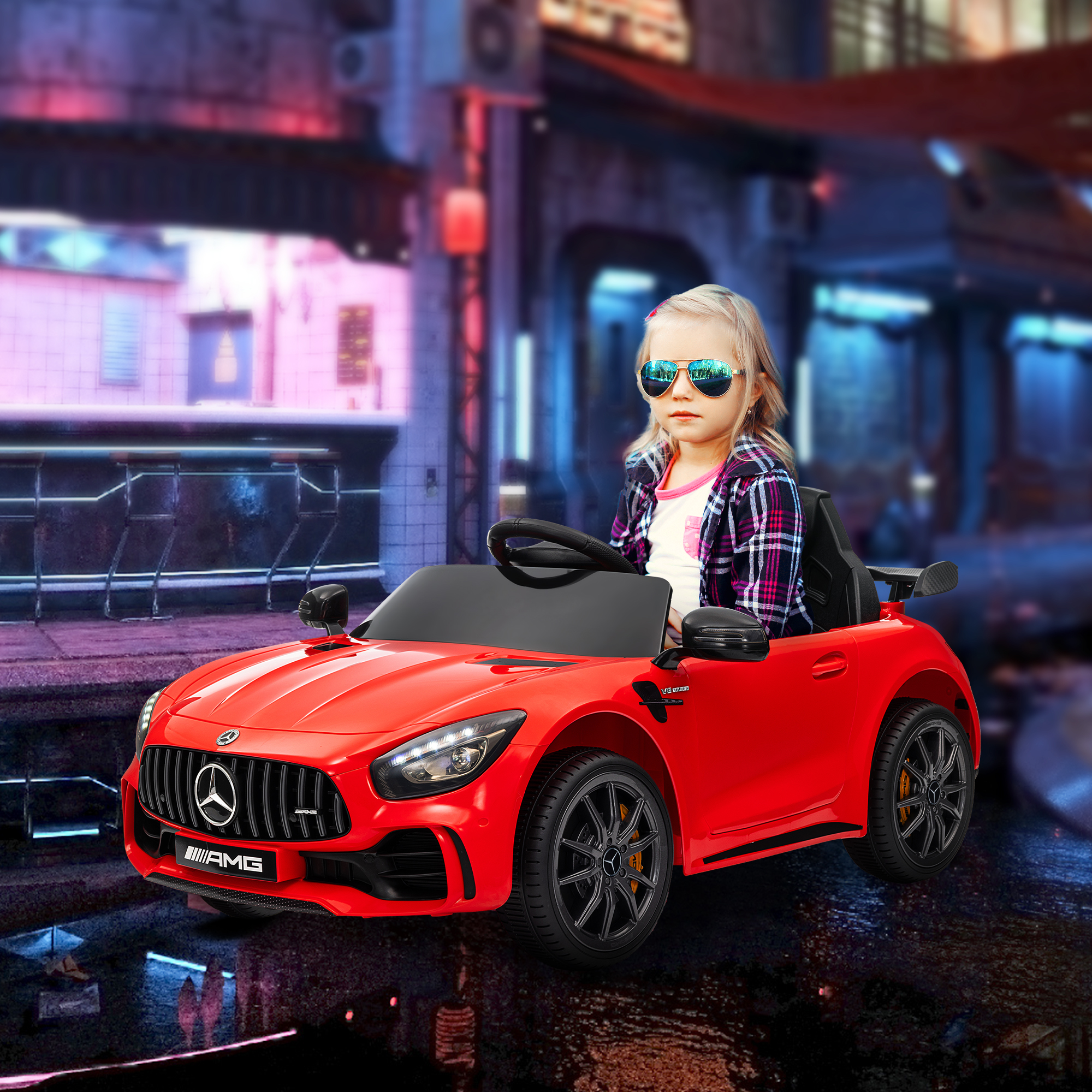 Una niña con gafas de sol conduciendo un coche de juguete rojo con la marca AMG en una escena urbana.