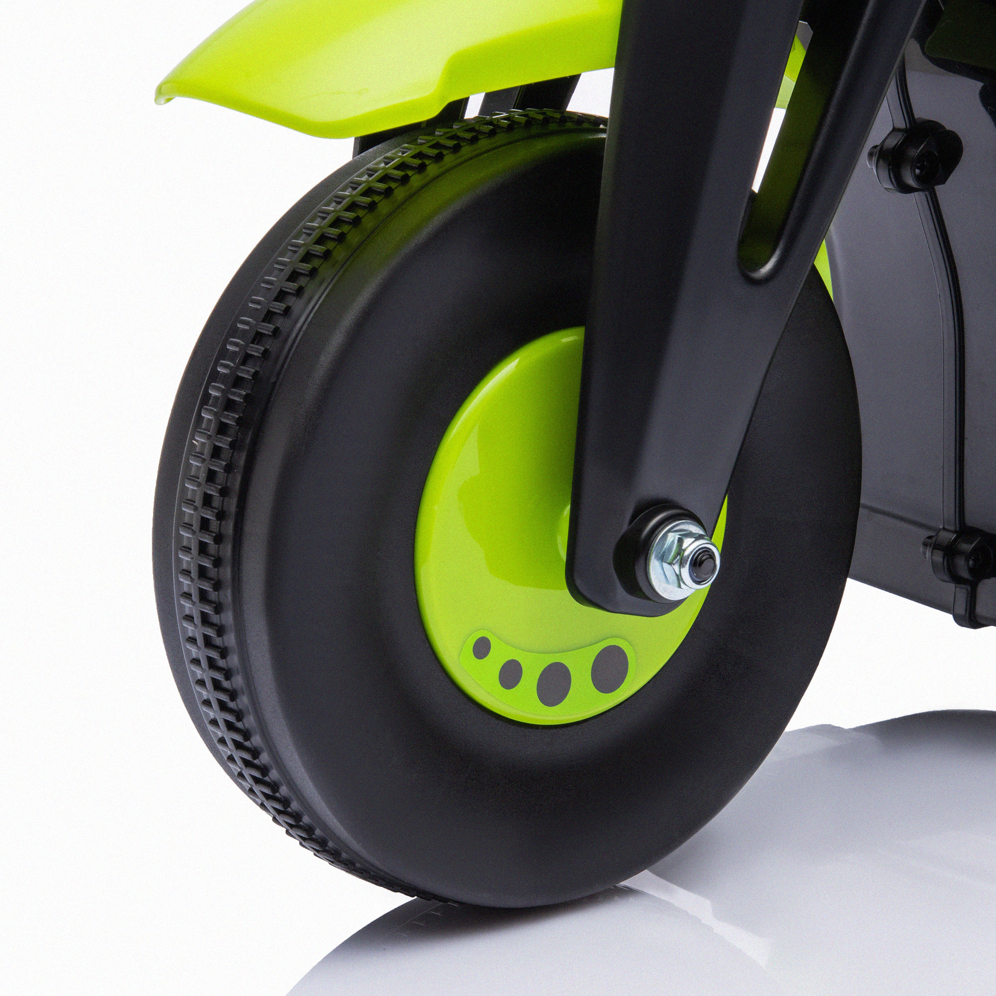 Primer plano de una rueda verde lima en una moto de juguete negra y verde. El neumático es negro.