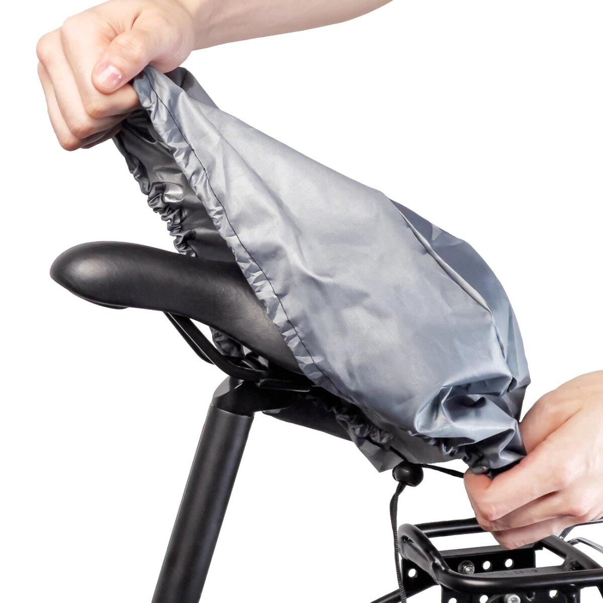 Eine Hand bedeckt einen Fahrradsattel mit einer grauen Regenhülle. Das Fahrrad ist schwarz, weißer Hintergrund.