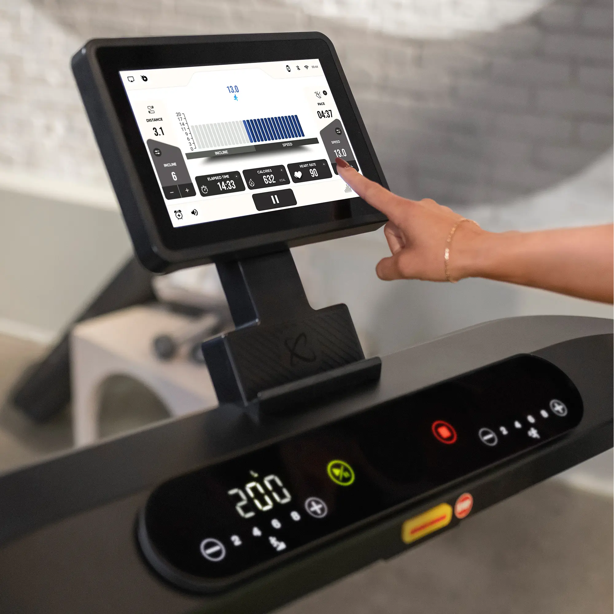 Treadmill screen showing workout data. Hand touching the screen to control it.