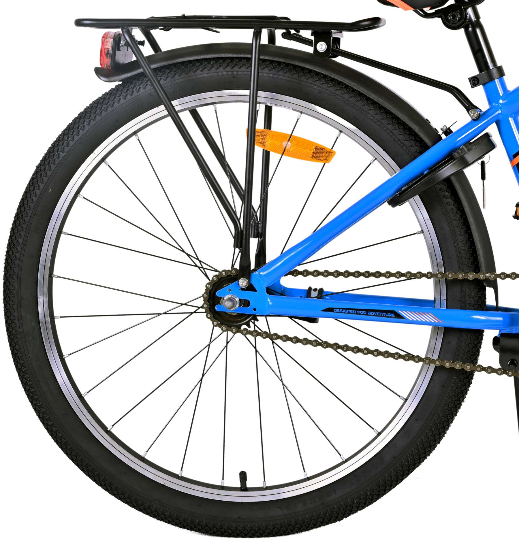 Blaues Fahrrad mit schwarzem Gepäckträger. Schwarze Reifen. Der Rahmen hat einen Aufkleber 'Designed for Adventure'.