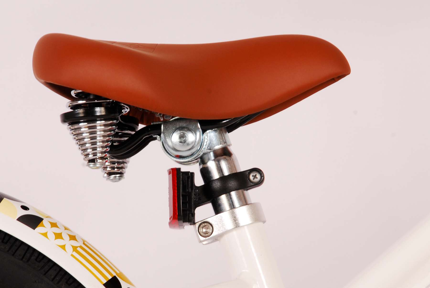 Ein brauner Fahrradsattel mit Federn und einem roten Licht.