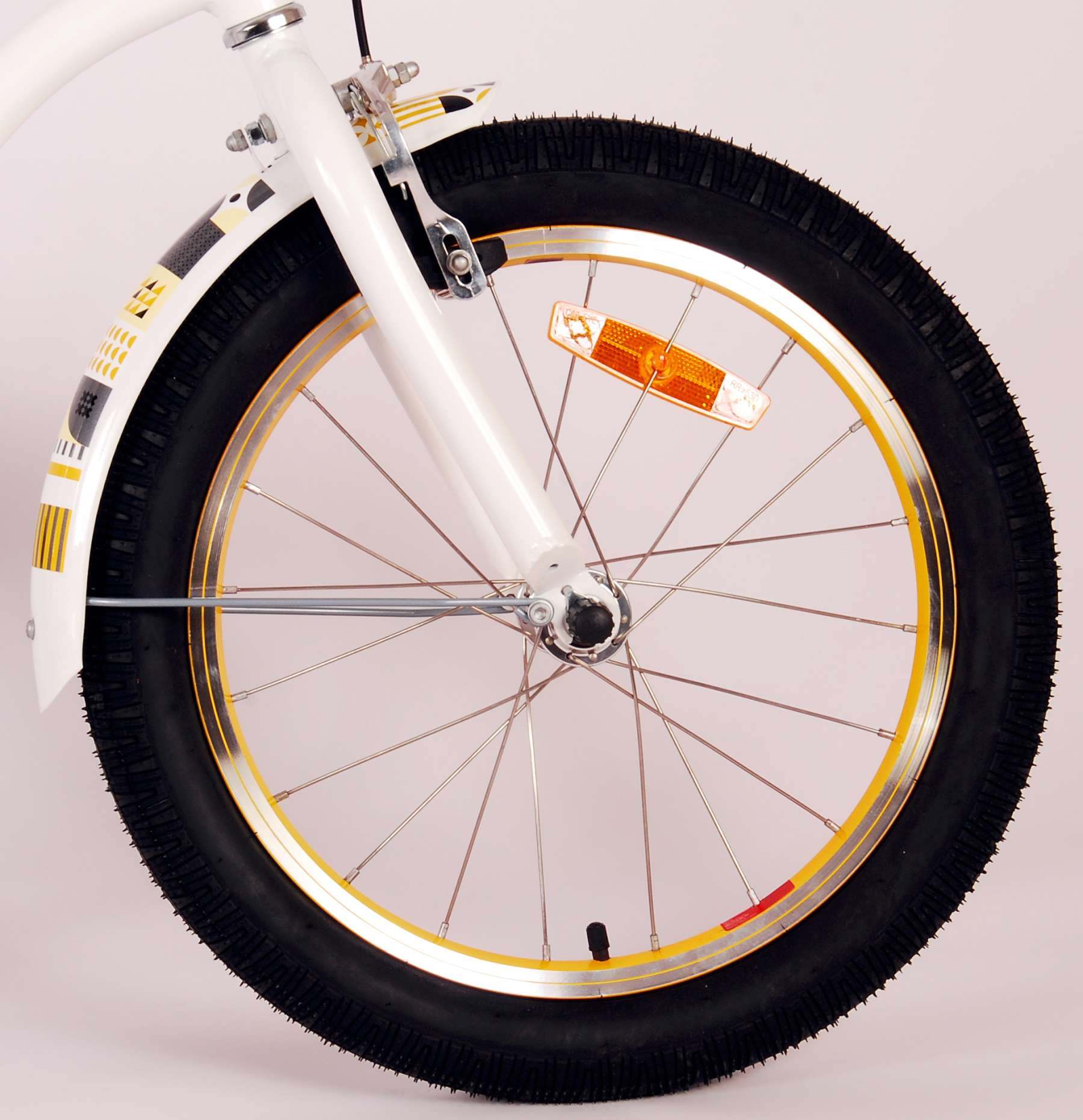 Nahaufnahme eines weißen Fahrradrads mit schwarzem Reifen, gelben Akzenten und einem orangefarbenen Reflektor.