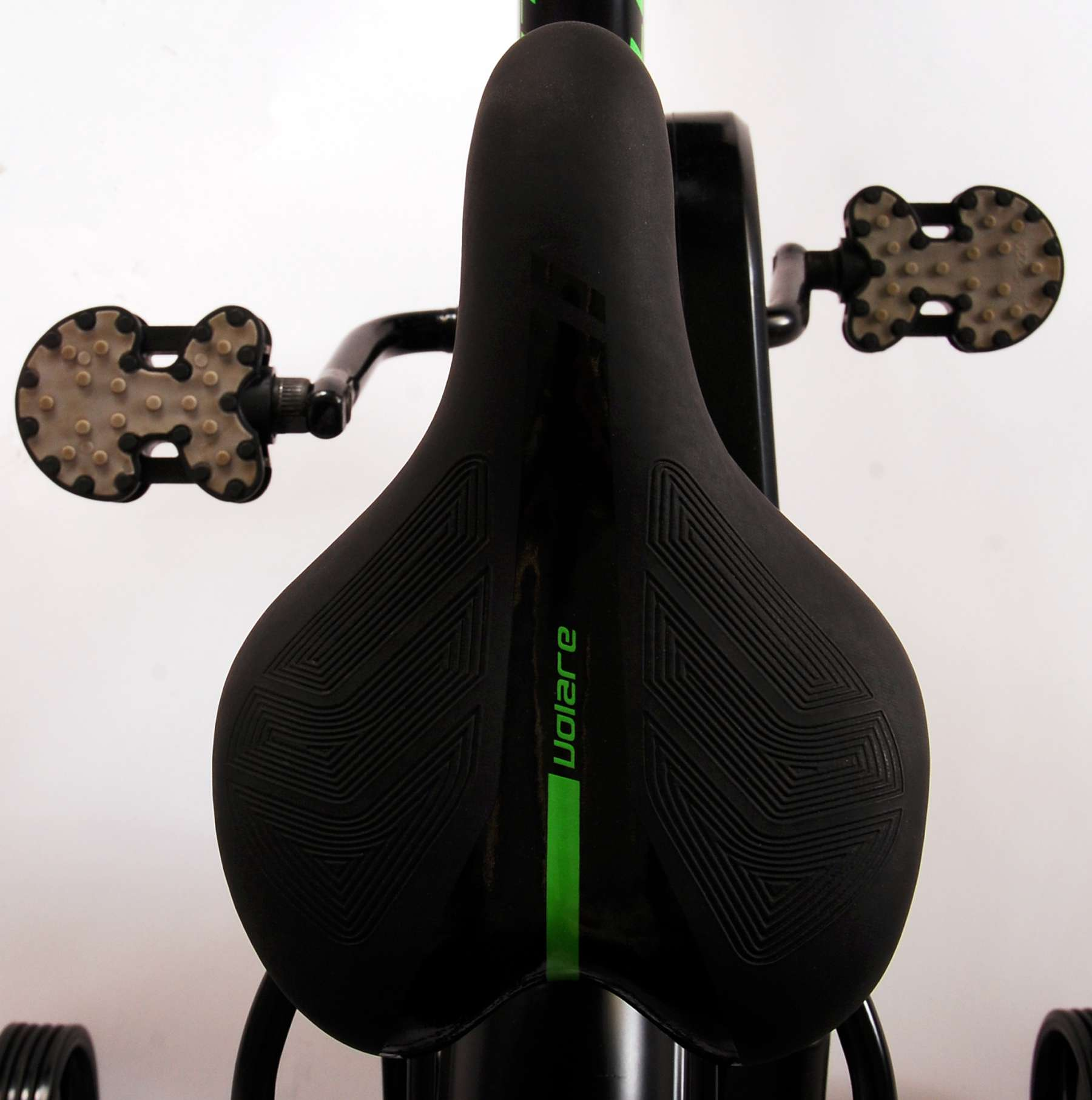 Schwarzer Fahrradsattel mit Volare-Logo und grünem Streifen, Pedale sichtbar.
