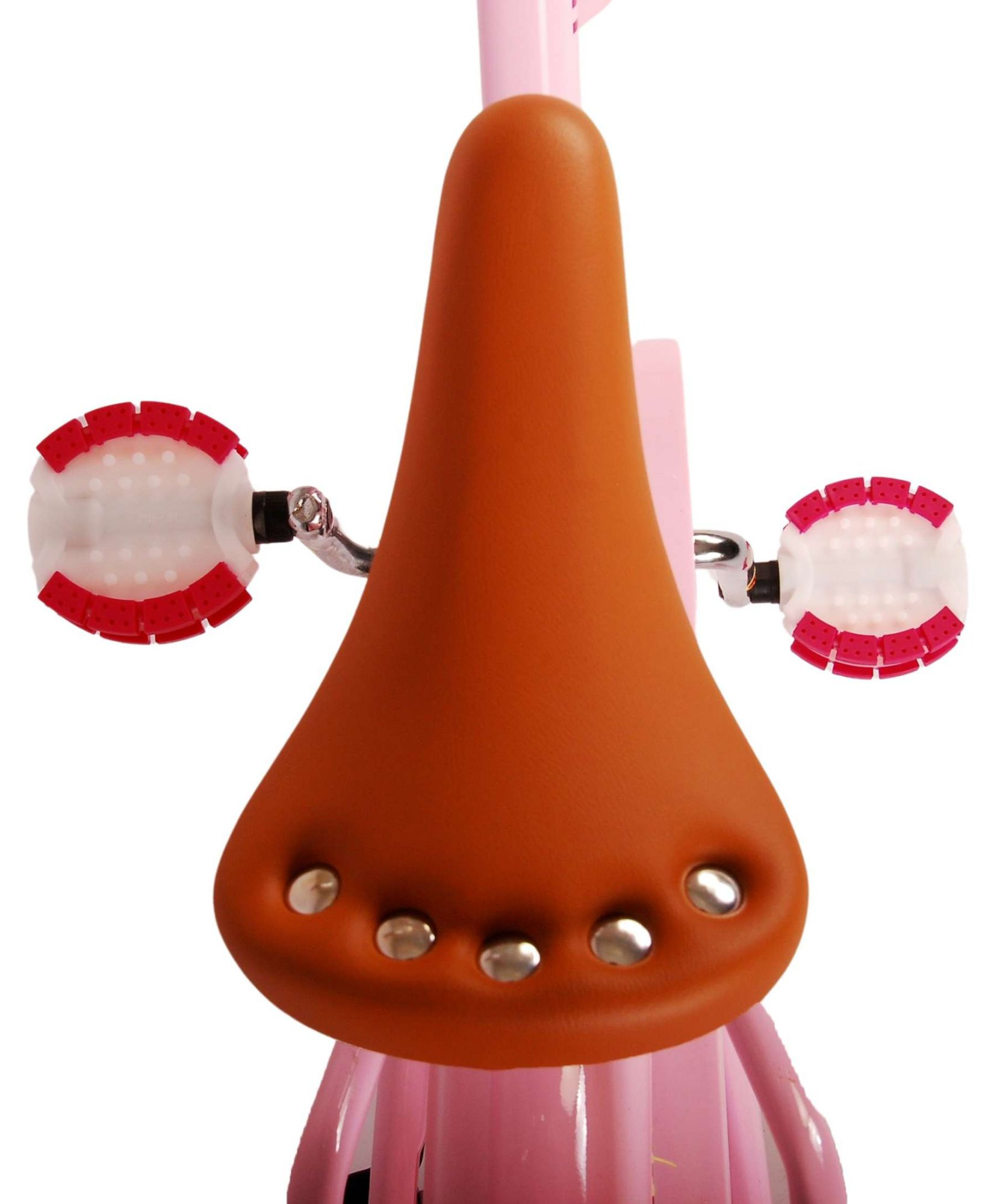 Nahaufnahme eines braunen Fahrradsattels mit silbernen Nieten und rosa Pedalen.