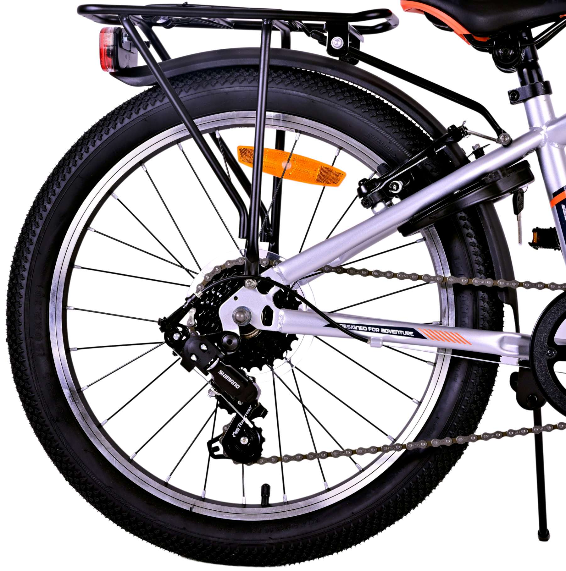 Hinterrad eines Fahrrads mit schwarzem Reifen. Silberner Rahmen, schwarzer Gepäckträger und Shimano-Getriebekomponenten.