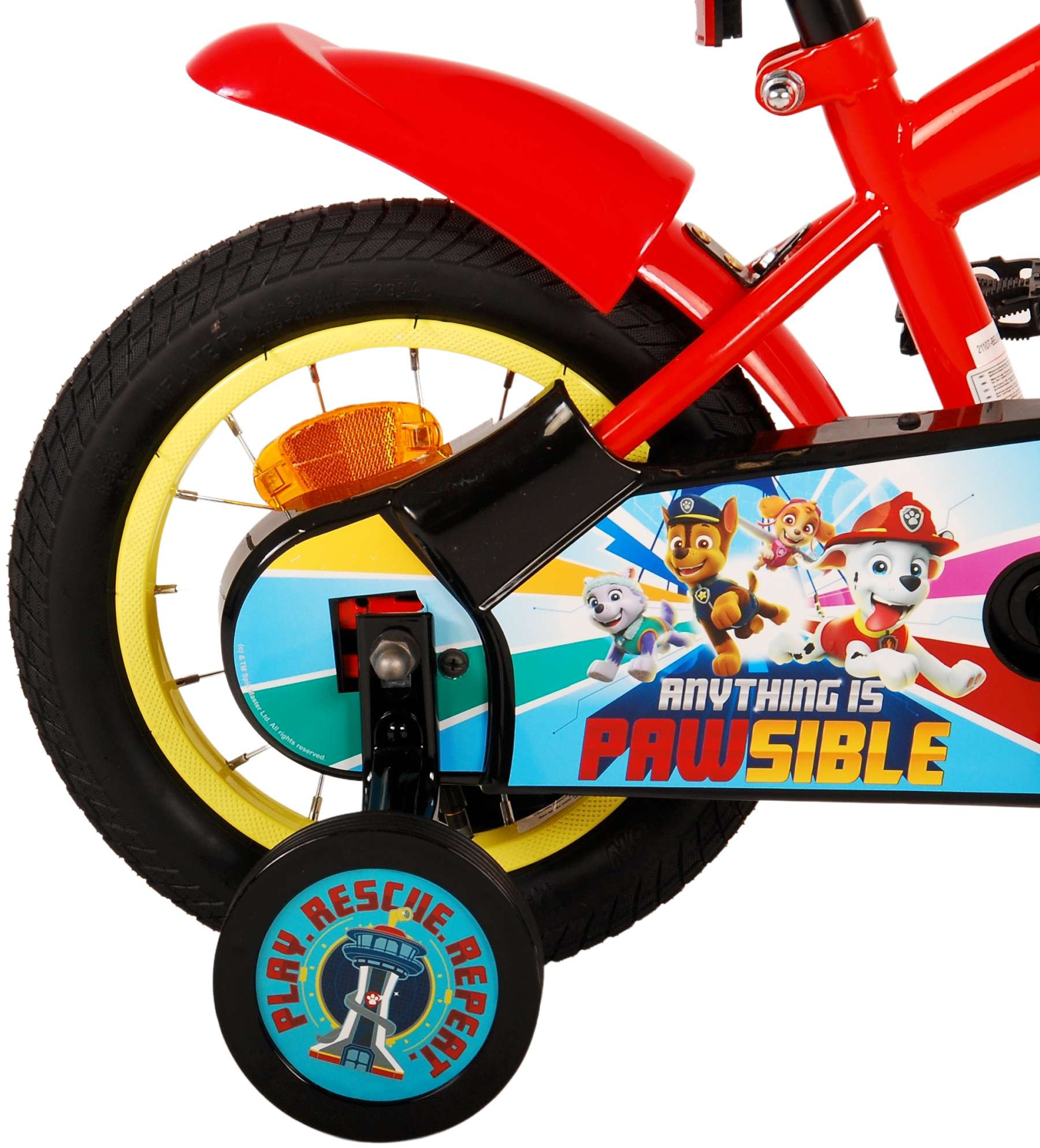 Nahaufnahme des Hinterrads eines roten Paw Patrol Fahrrads. Stützräder und Paw Patrol Charaktere sichtbar.