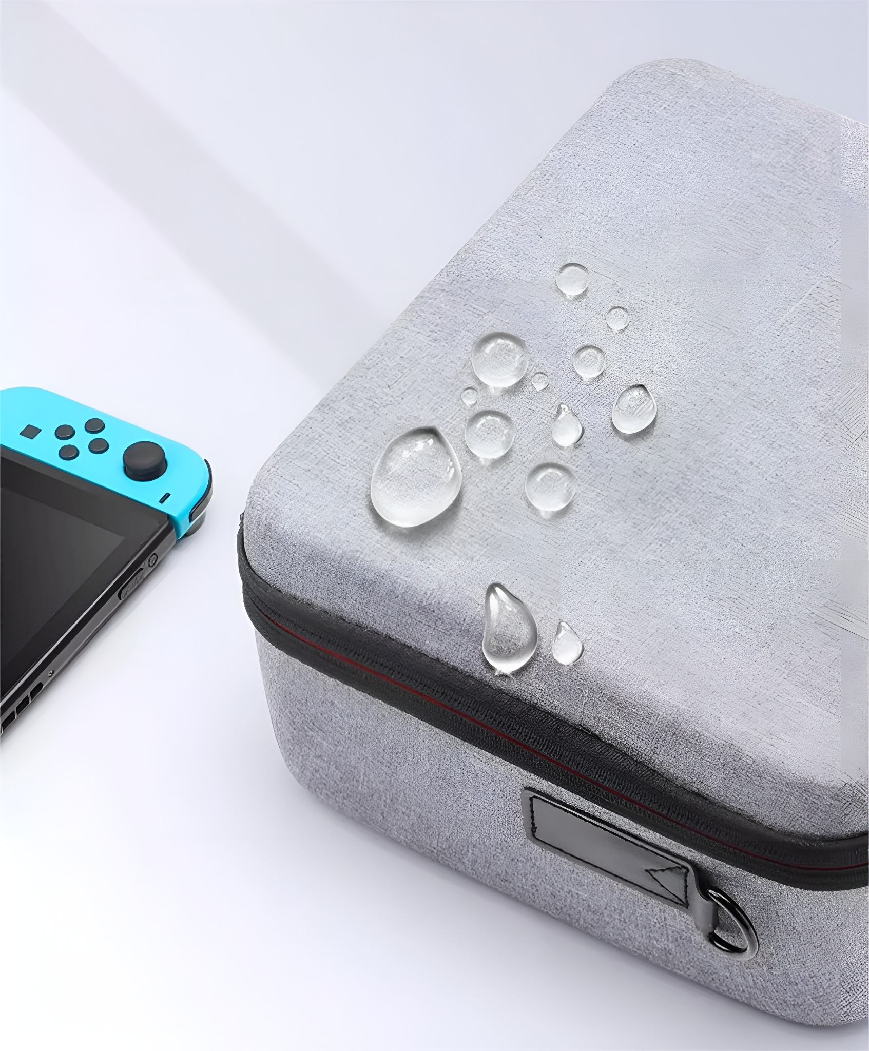Graue Switch-Tragetasche mit Wassertropfen und eine blaue Nintendo Switch-Konsole an der Seite.