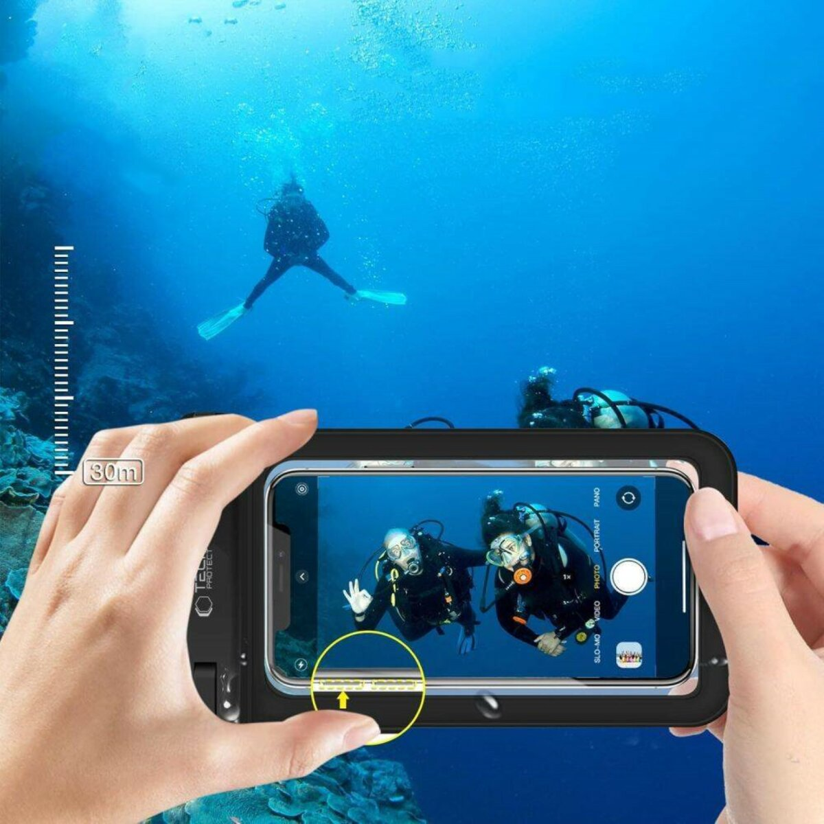 Persona che tiene un telefono in custodia subacquea, riprendendo subacquei nell'oceano. Indicatore di profondità visibile.