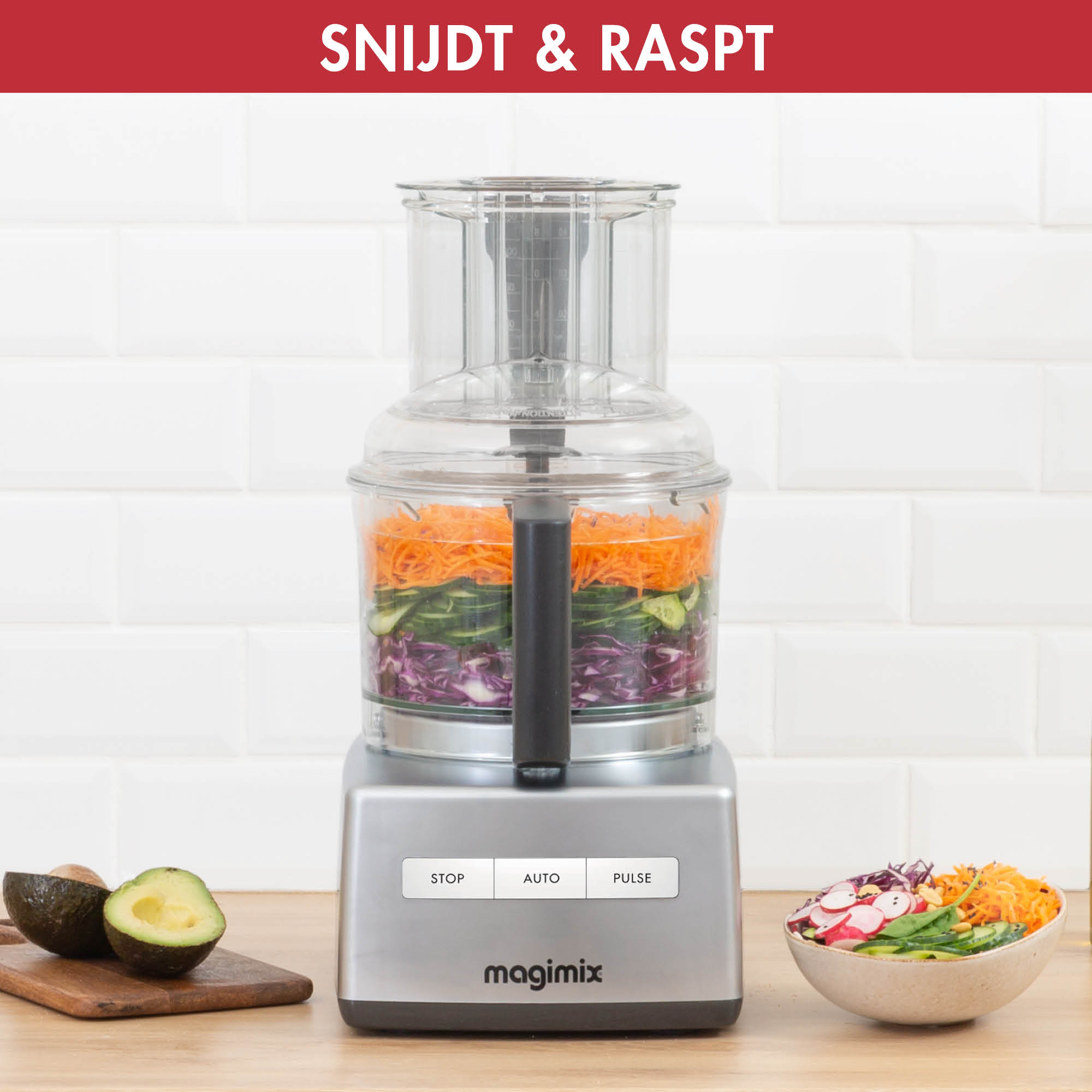 A food processor is slicing vegetables, with sliced vegetables and avocados on the side.