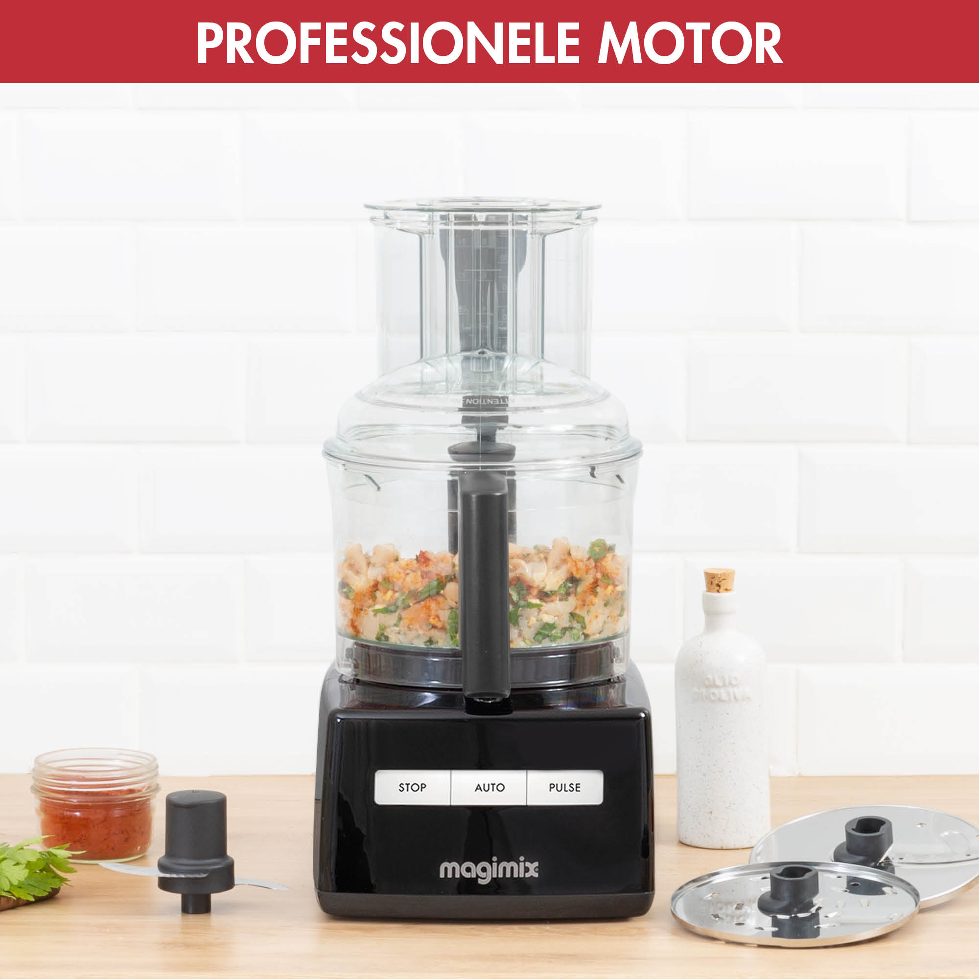 A black food processor with ingredients inside and various attachments is shown.