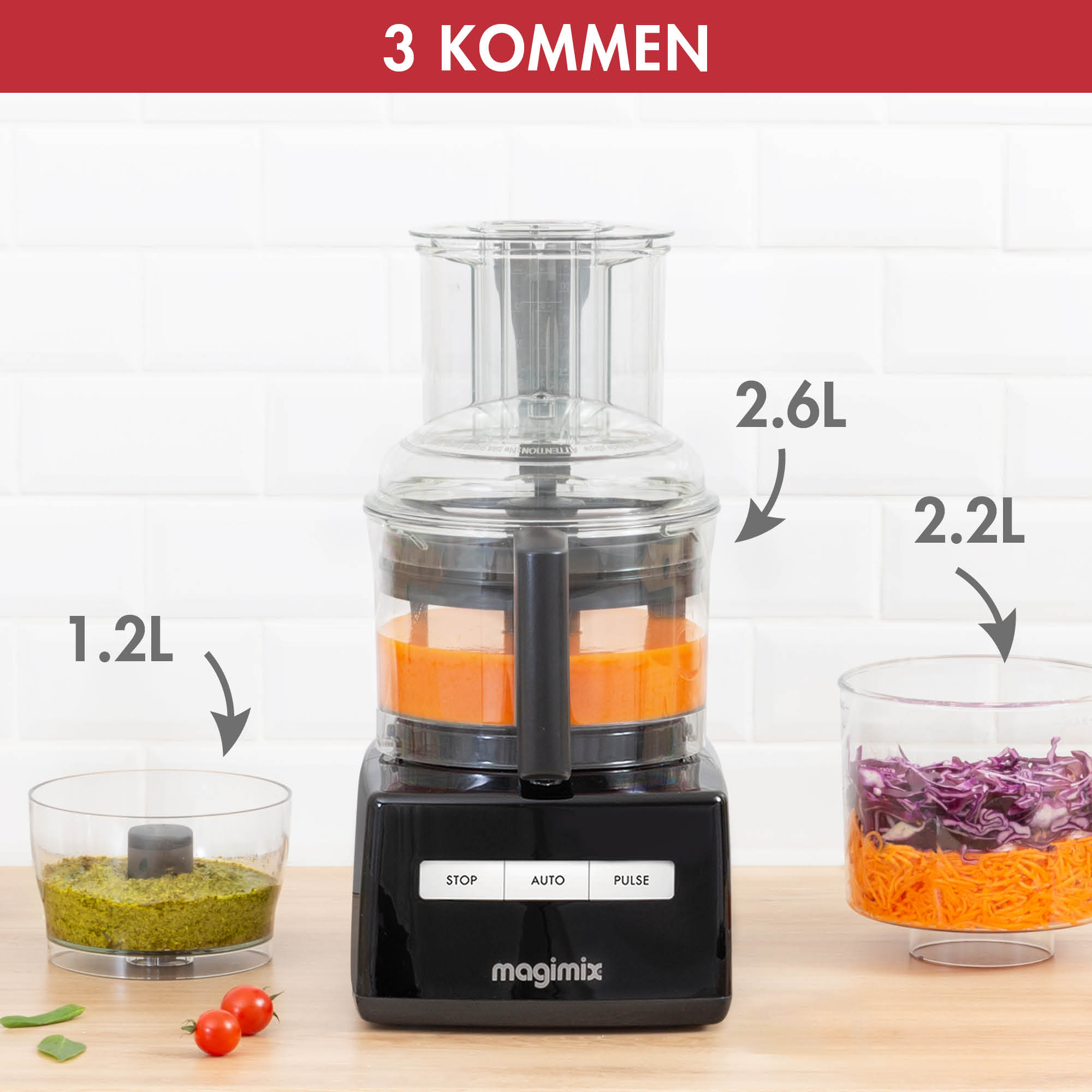 A black food processor with three containers. One has green pesto, another orange, and the last, red cabbage.