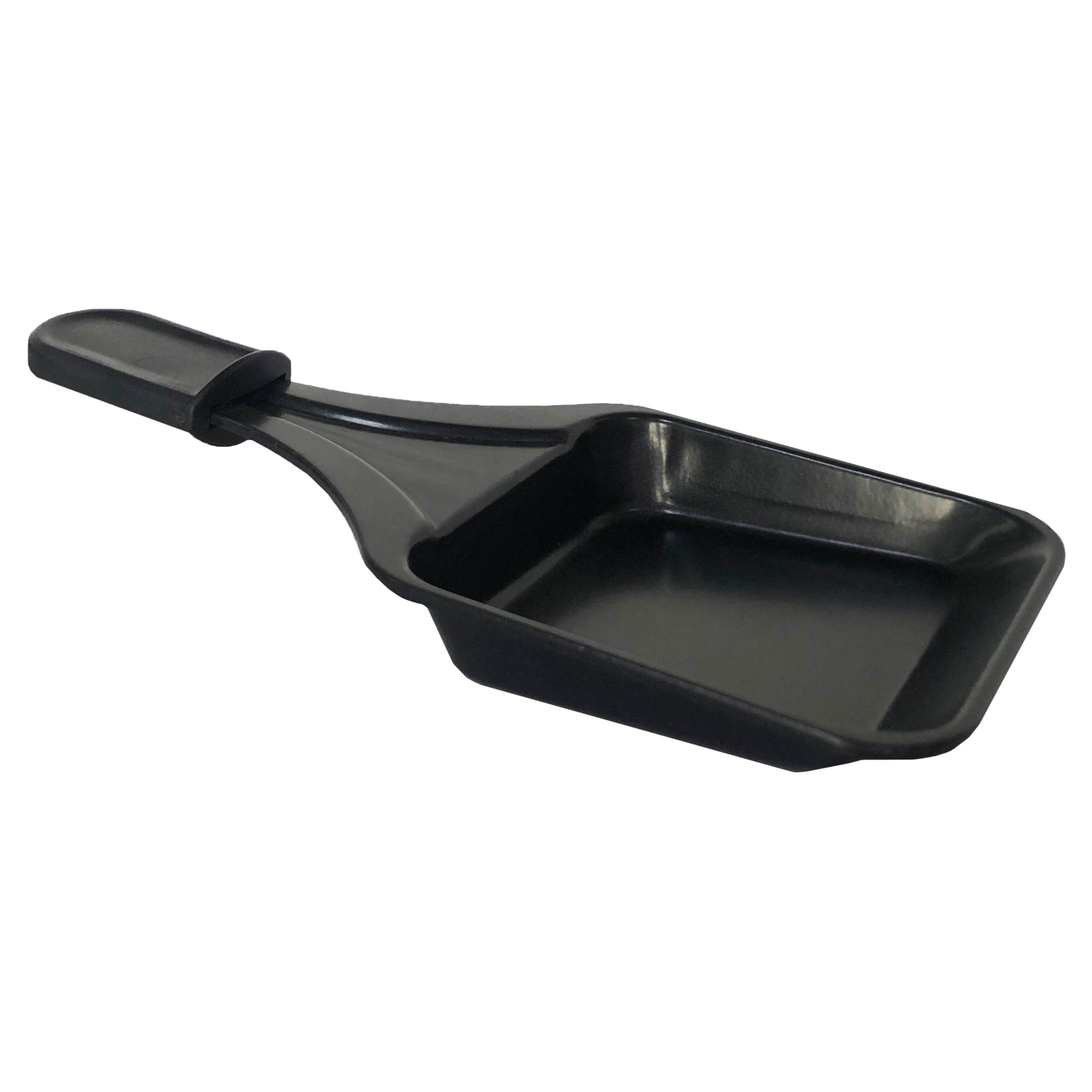 Een zwarte raclettepan met een handvat, van bovenaf gezien, geïsoleerd op een witte achtergrond.