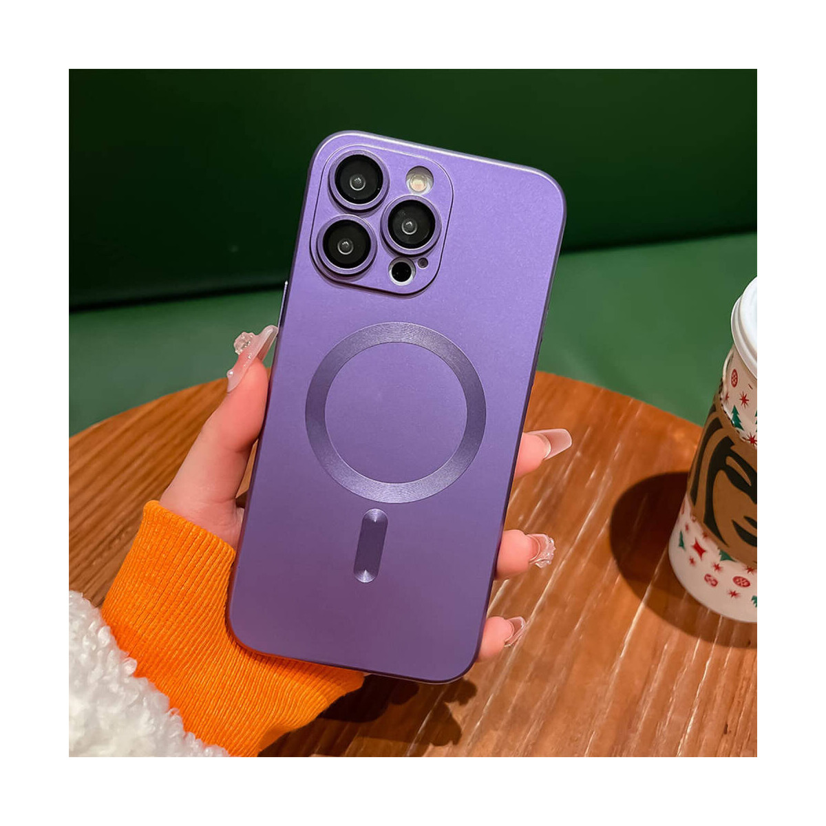 Custodia per telefono viola con anello sul retro. Il telefono è su un tavolo di legno con una tazza.