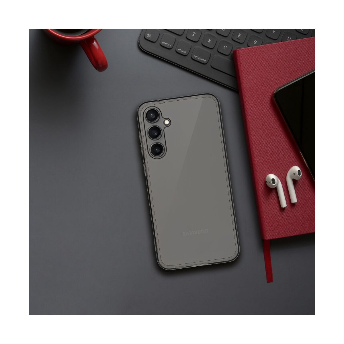 Smartphone con custodia, tastiera, taccuino e auricolari su una superficie scura.