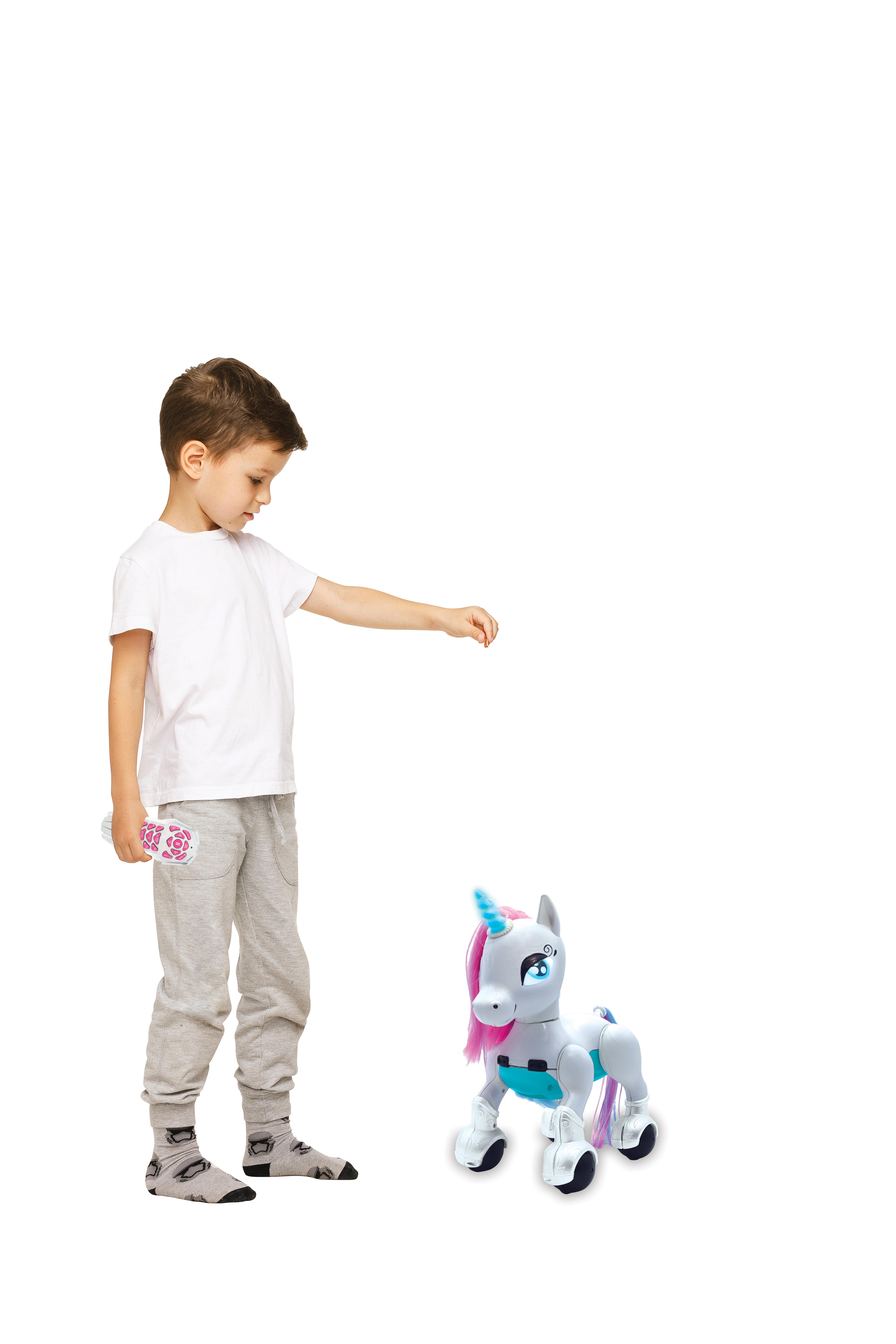 Un bambino indica un unicorno giocattolo. L'unicorno è bianco e blu con criniera e coda rosa.