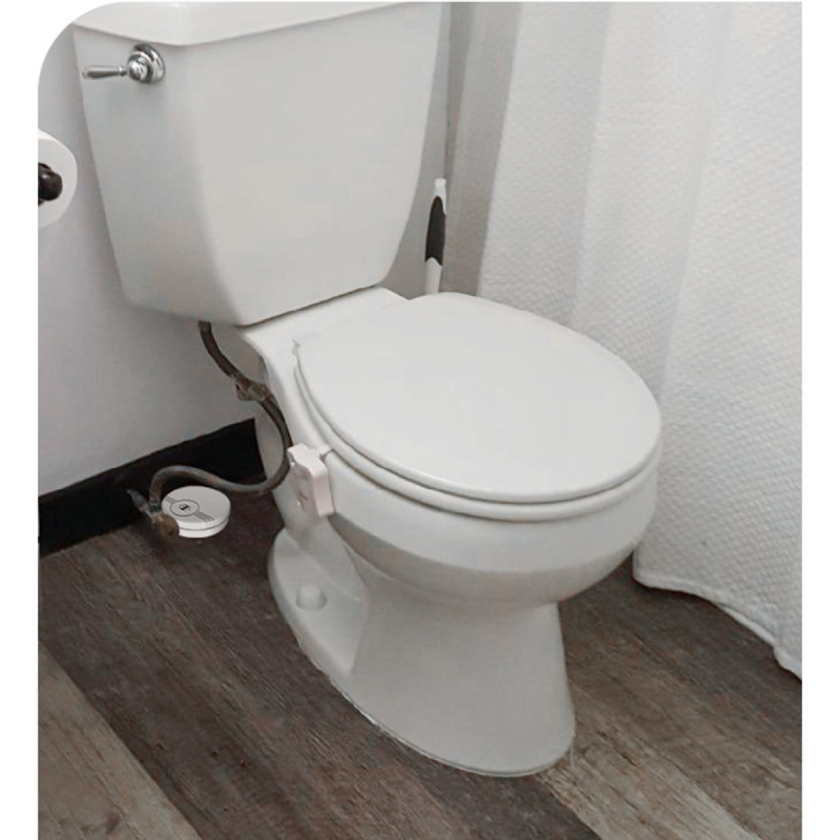 Weiße Toilette mit geschlossenem Deckel, auf Holzboden.
