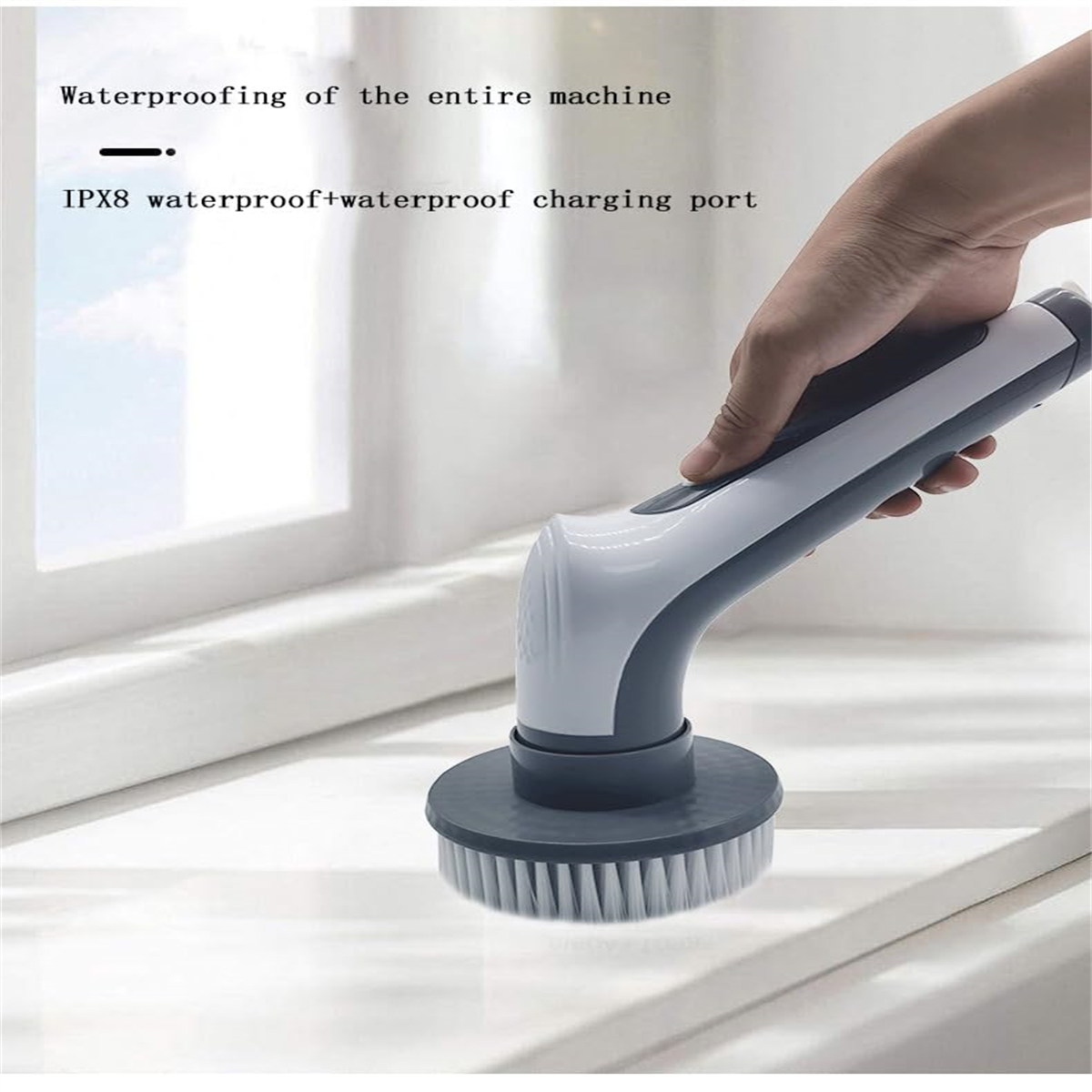 Hand, die eine weiße und graue elektrische Reinigungsbürste über einer Oberfläche hält. IPX8 wasserdicht.