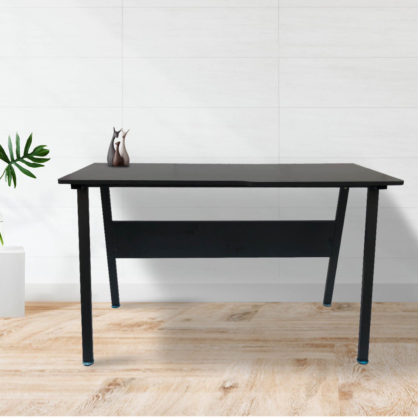 Een zwart bureau met een eenvoudig ontwerp en een klein decoratief item op een lichte houten vloer.