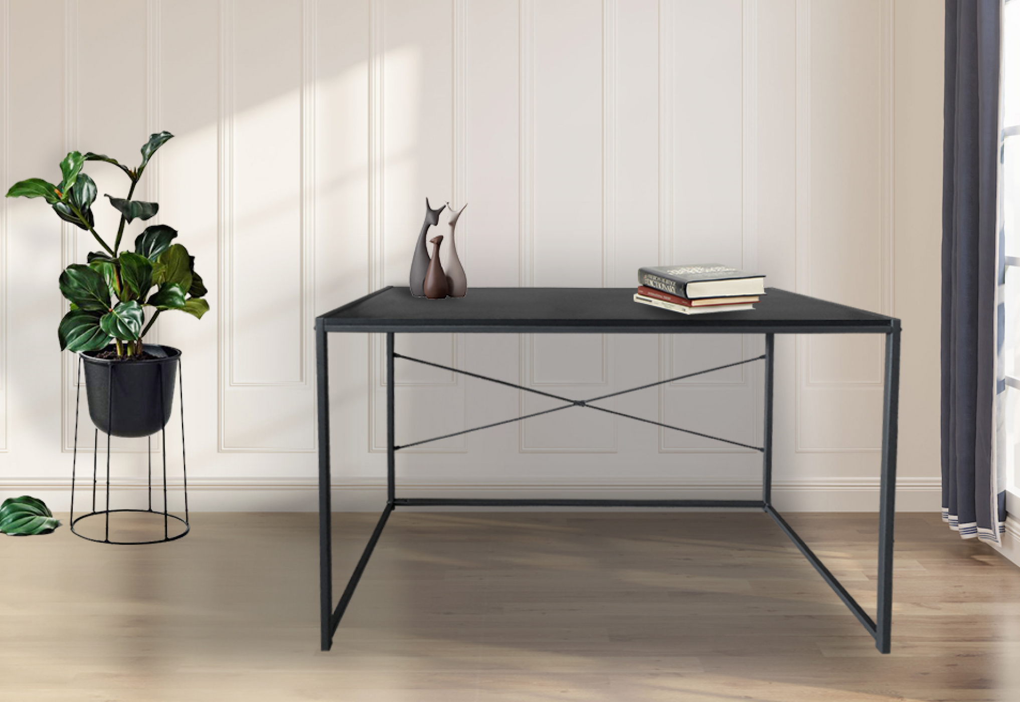 Zwart bureau met metalen poten. Plant in pot links, boeken en decoratie bovenop.
