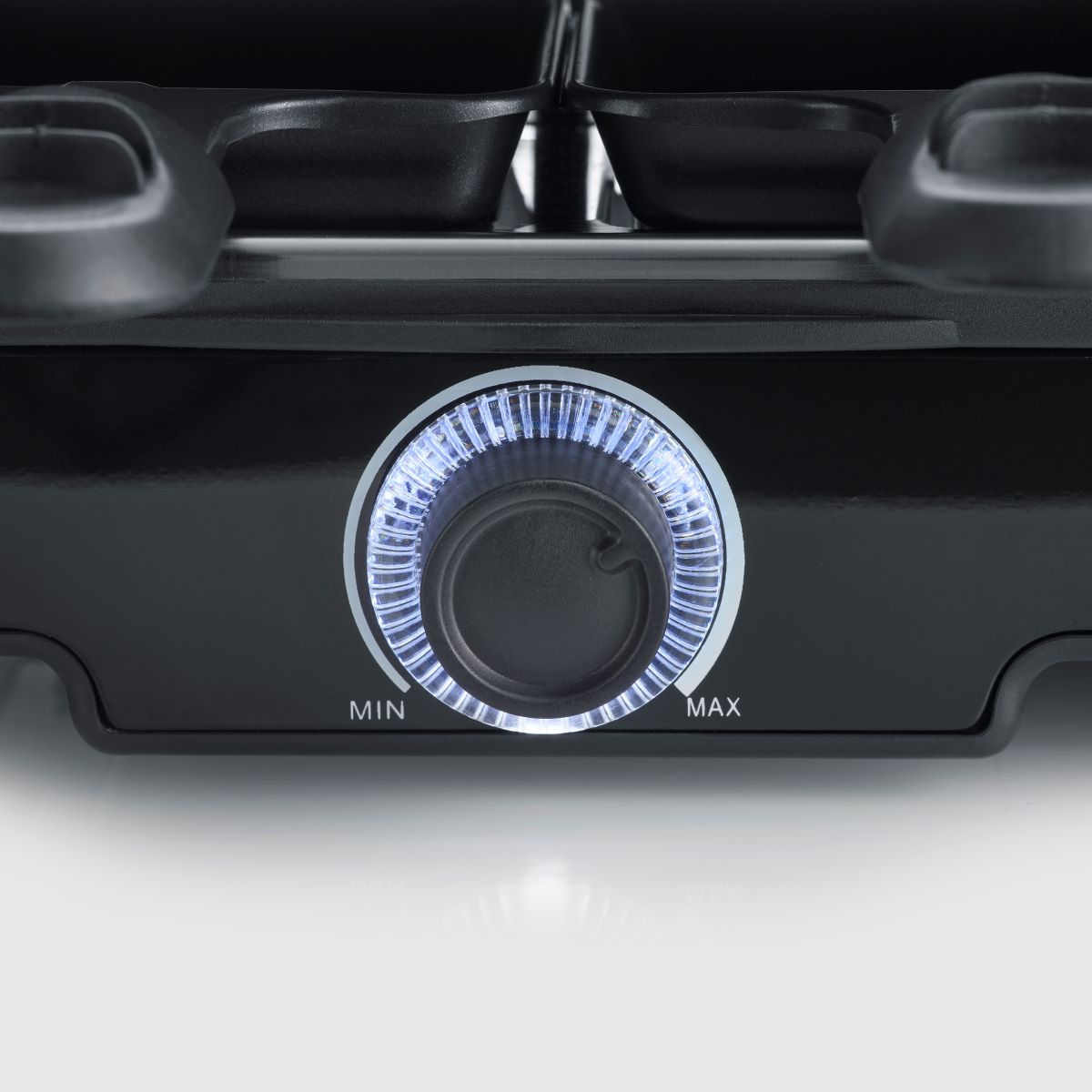 Zbliżenie czarnego pokrętła z niebieskim podświetleniem, oznaczone 'MIN' i 'MAX'. Białe tło.
