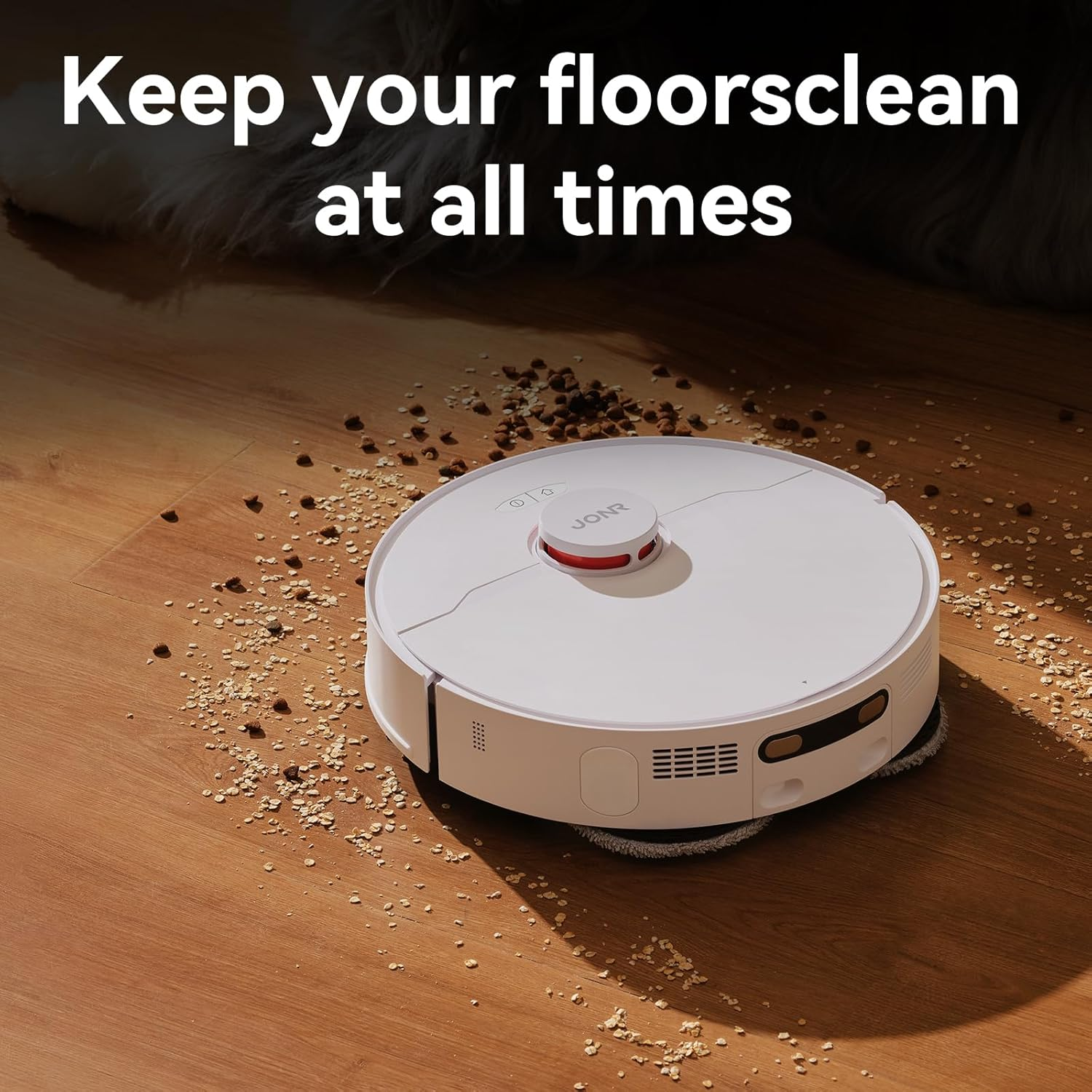 Ein weißer Roboter-Staubsauger mit rotem Knopf auf einem Holzboden mit Schmutz.