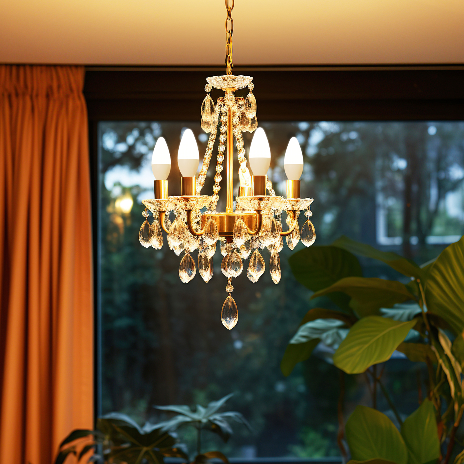 Ein goldener Kronleuchter mit Kristallen hängt vor einem Fenster mit grünen Pflanzen im Hintergrund.