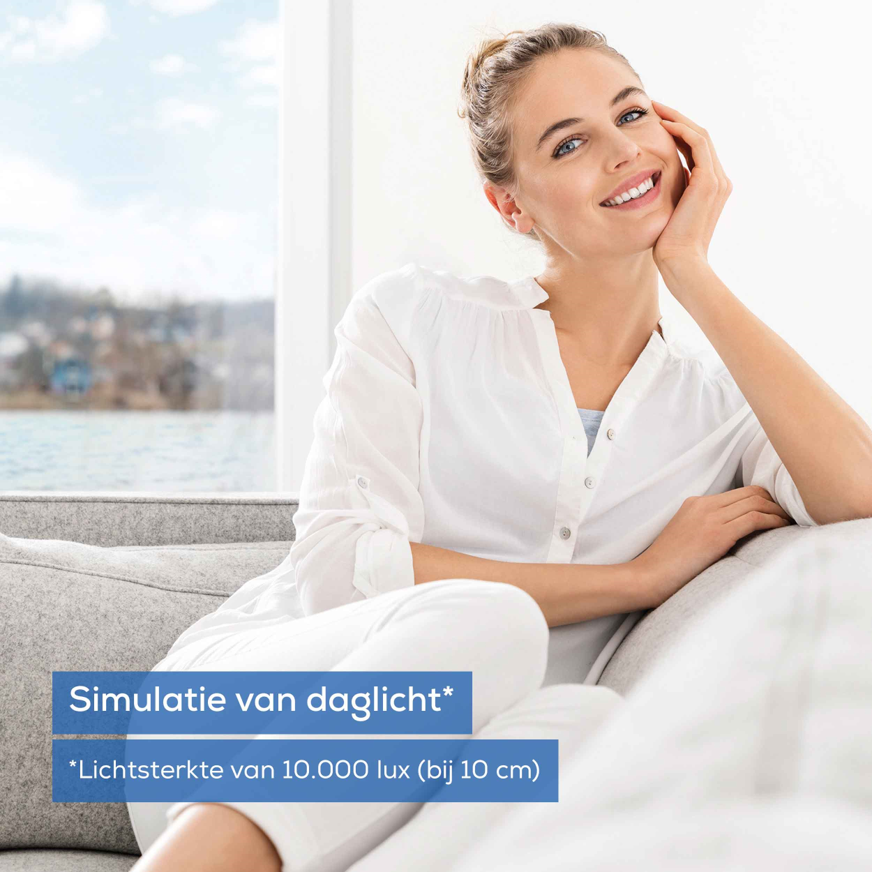 A woman smiles on a couch. Text says 'Simulation of daylight' and 'Light intensity of 10,000 lux'.