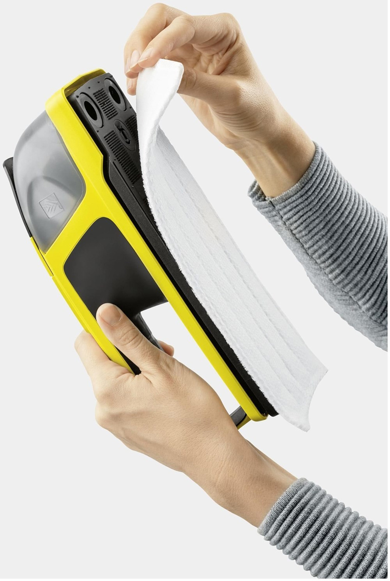 Dłonie trzymają żółto-czarną myjkę do okien. Biała wkładka czyszcząca jest wkładana.