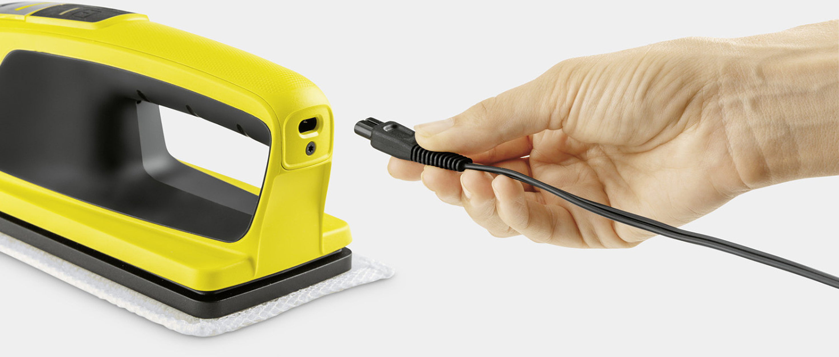 Żółte narzędzie do czyszczenia z ręką trzymającą wtyczkę. Białe tło.