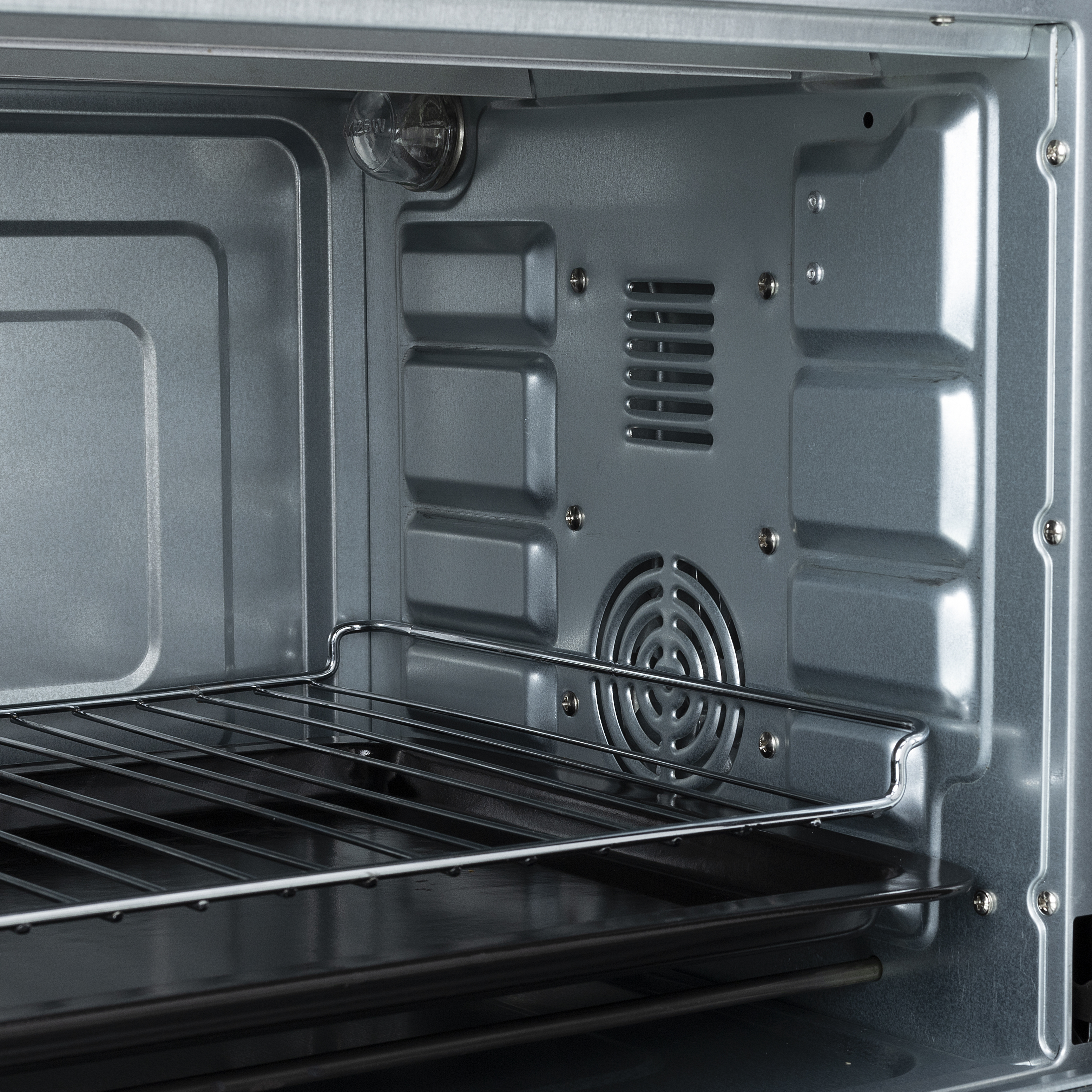 L'interno di un forno, che mostra le pareti interne, una ventola e una griglia metallica.