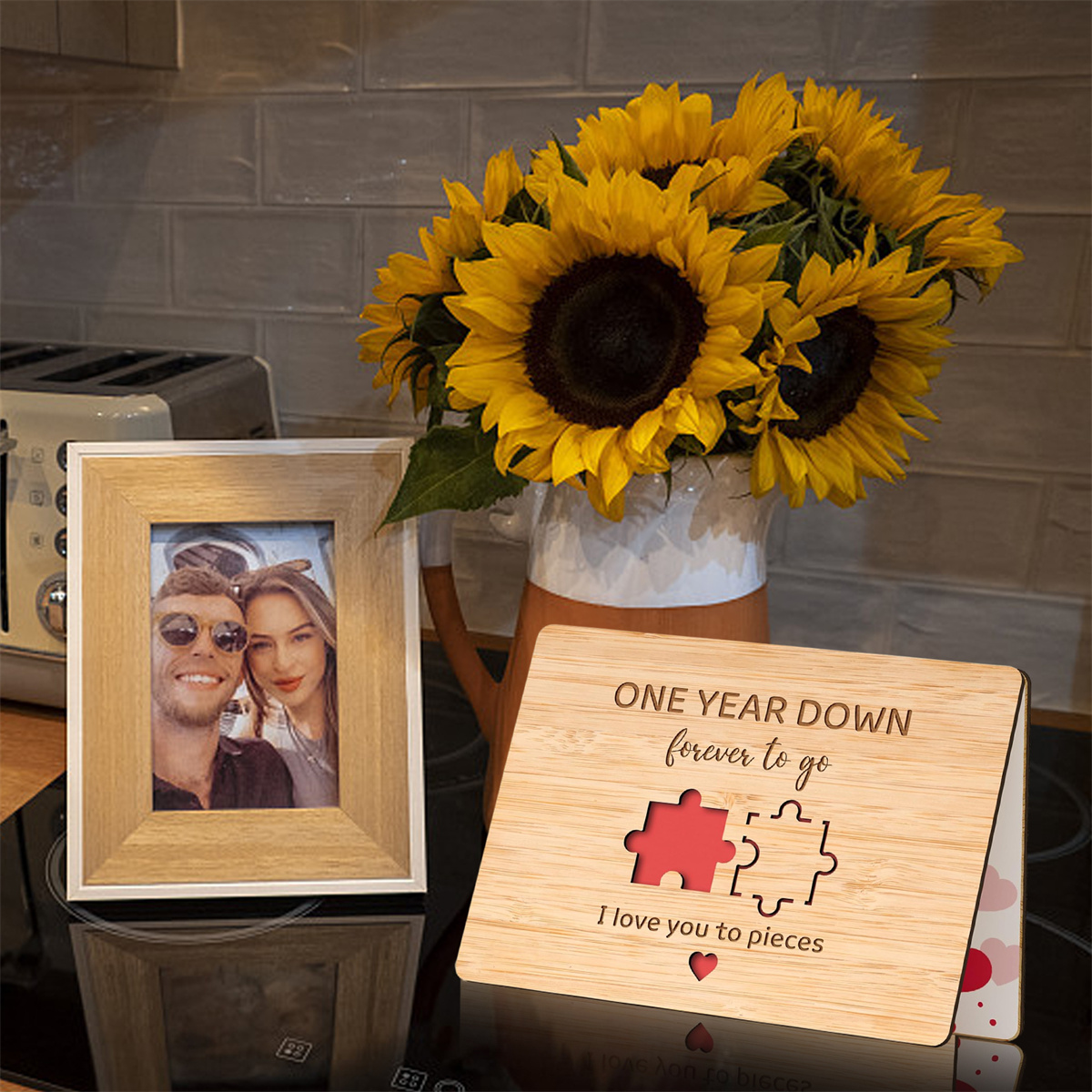 Fotorahmen, Holzpuzzle und Sonnenblumen auf einem Tisch, feiern ein einjähriges Jubiläum.