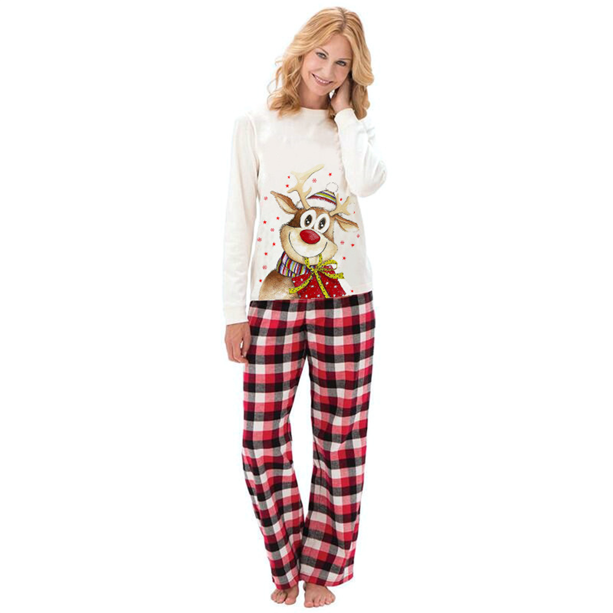 Eine Frau in Weihnachtspyjamas lächelt vor weißem Hintergrund.