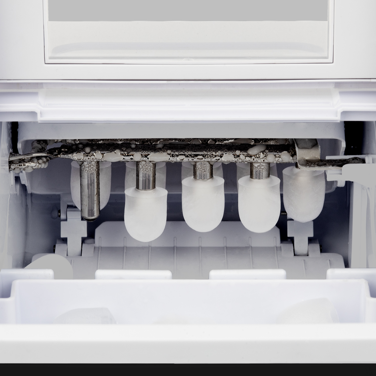 Wnętrze maszyny do lodu z elementami do produkcji lodu, białe i chromowane.