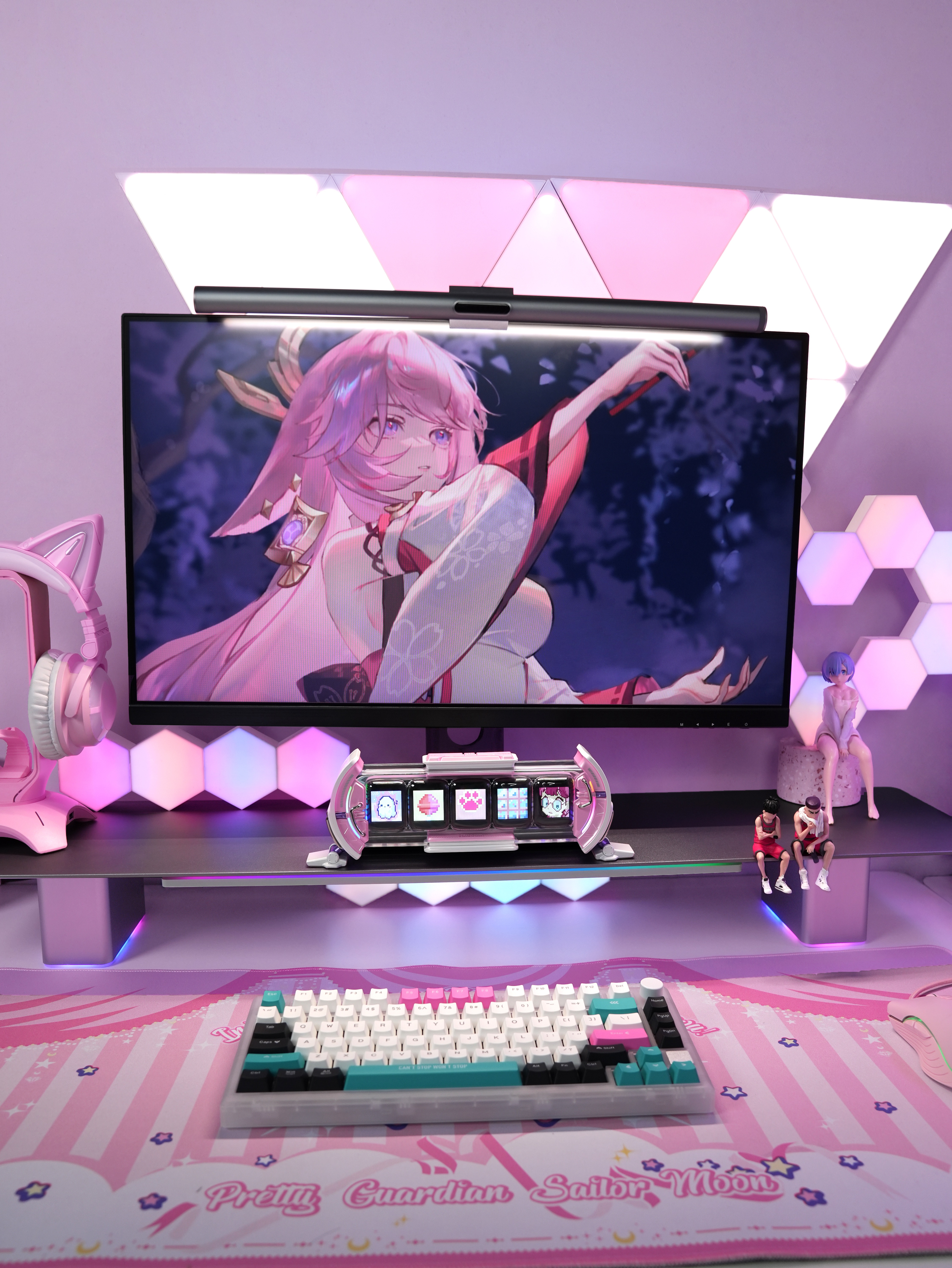 Bir anime karakteri gösteren bir monitörle oyun kurulumu. Klavye, ışıklar ve aksesuarlar içerir.