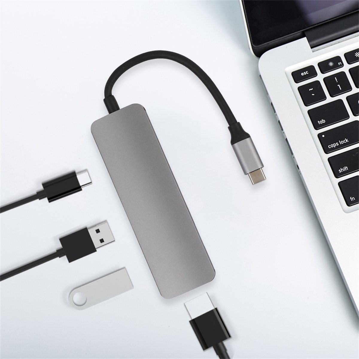Ein grauer USB-C-Hub mit mehreren Anschlüssen und angeschlossenen Kabeln.