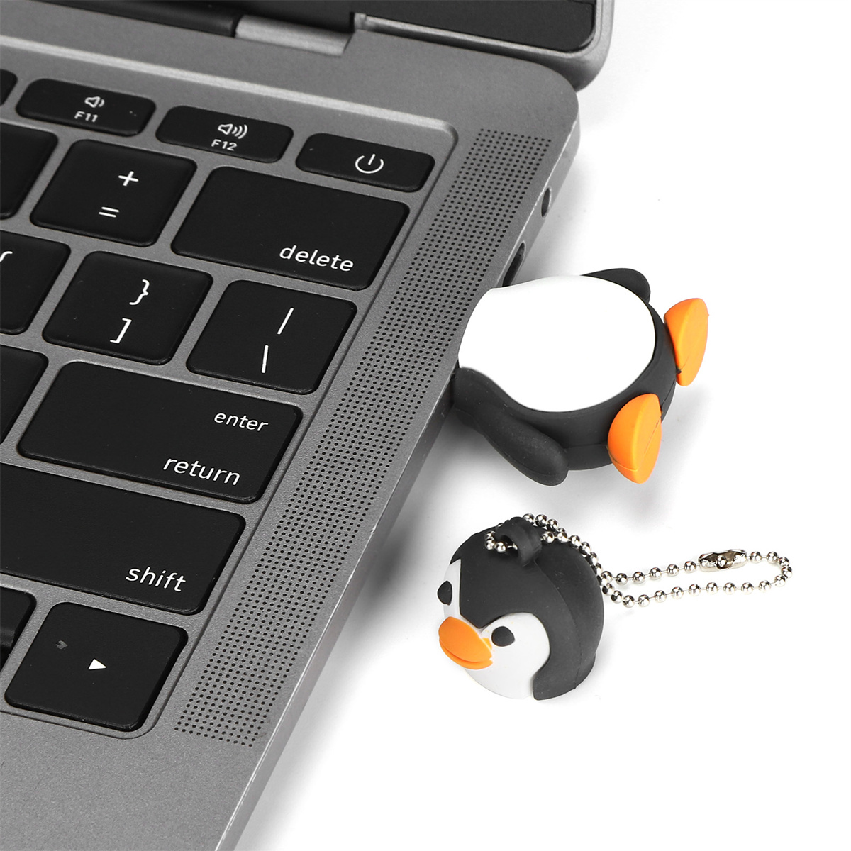 Ein Pinguin-USB-Stick neben einem Laptop und eine Schlüsselanhänger-Version.