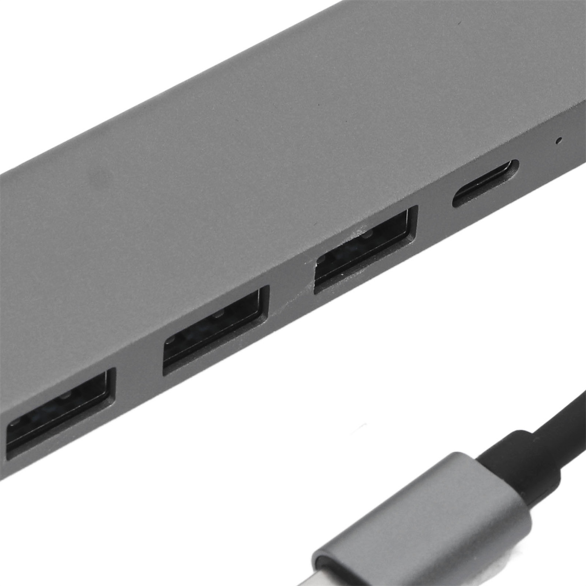 Grauer USB-Hub mit mehreren Anschlüssen und einem USB-C-Kabel. Nahaufnahme, weißer Hintergrund.
