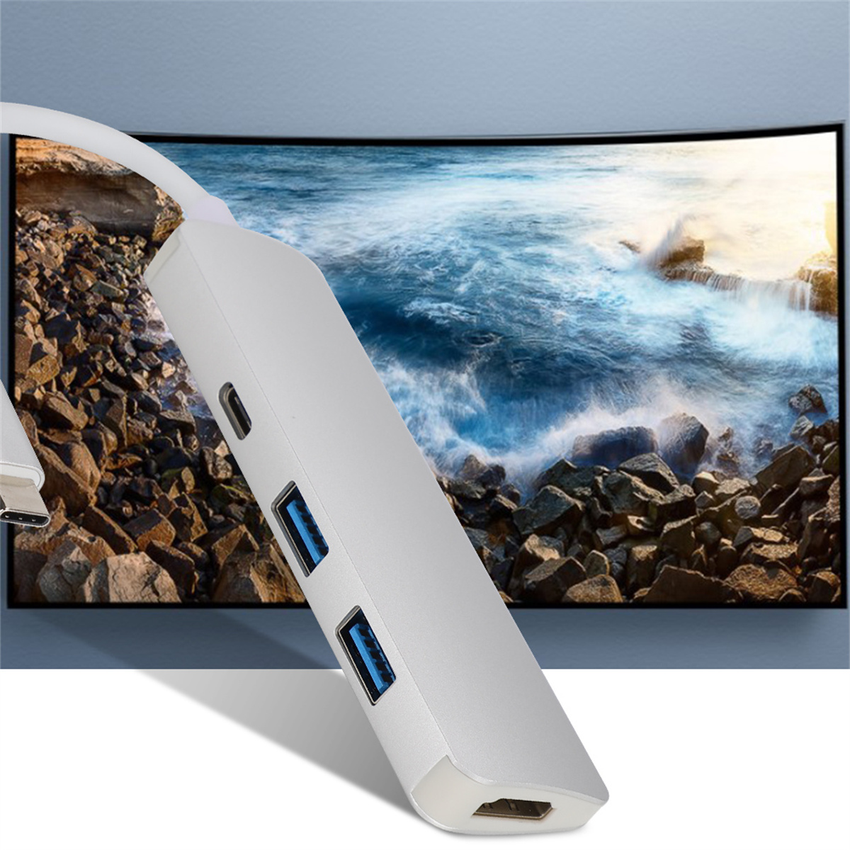 Weißer USB-Hub mit zwei USB-Anschlüssen, USB-C und HDMI, vor verschwommenem Bildschirm.