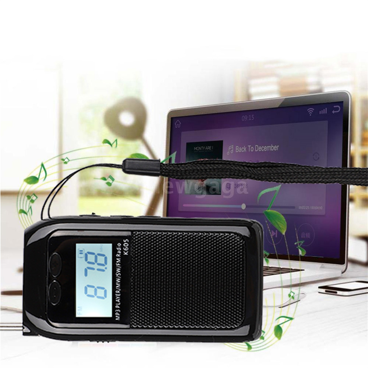 Schwarzes tragbares Radio mit Digitalanzeige neben einem Laptop.