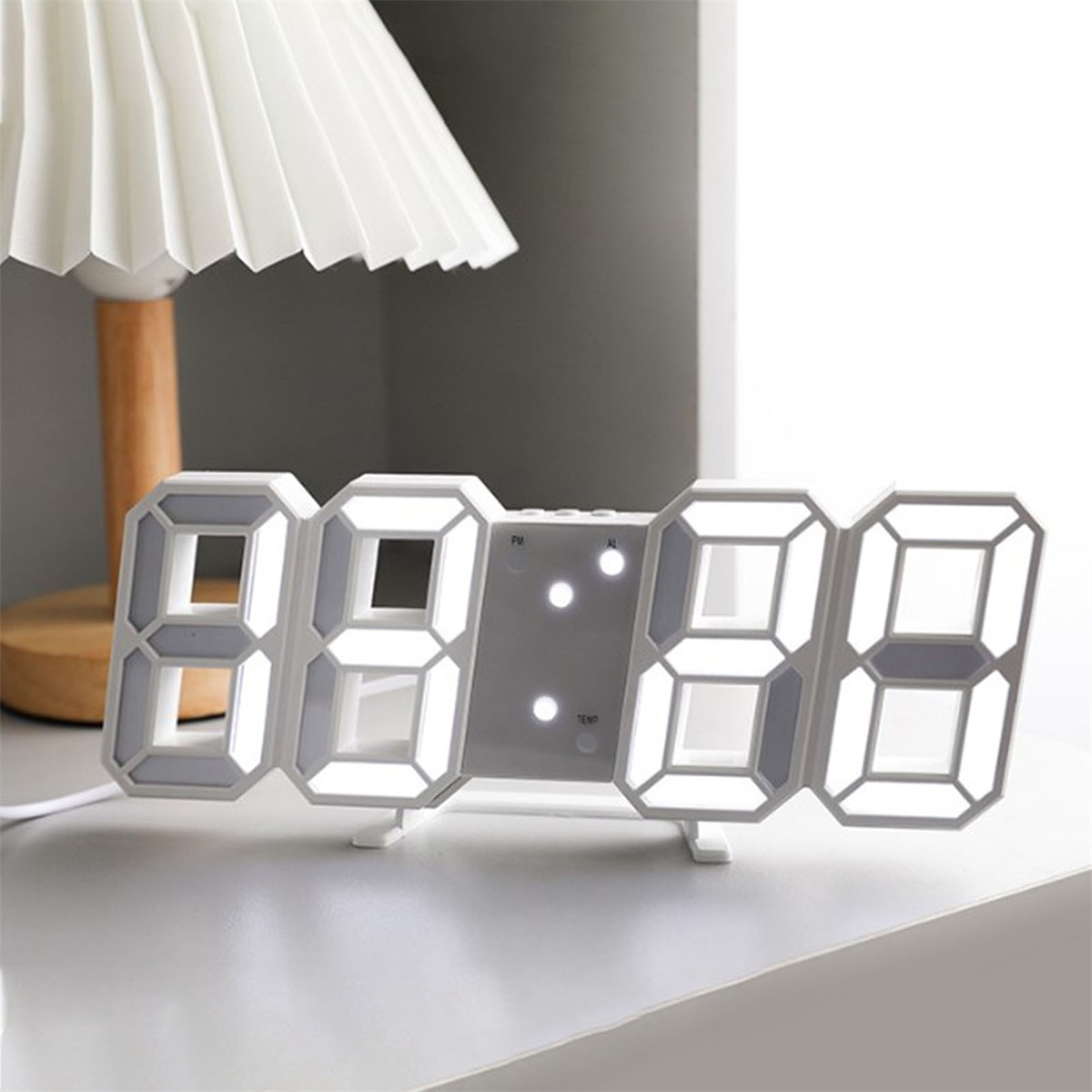 Digitaluhr mit der Anzeige 08:28. Im Hintergrund eine Lampe.