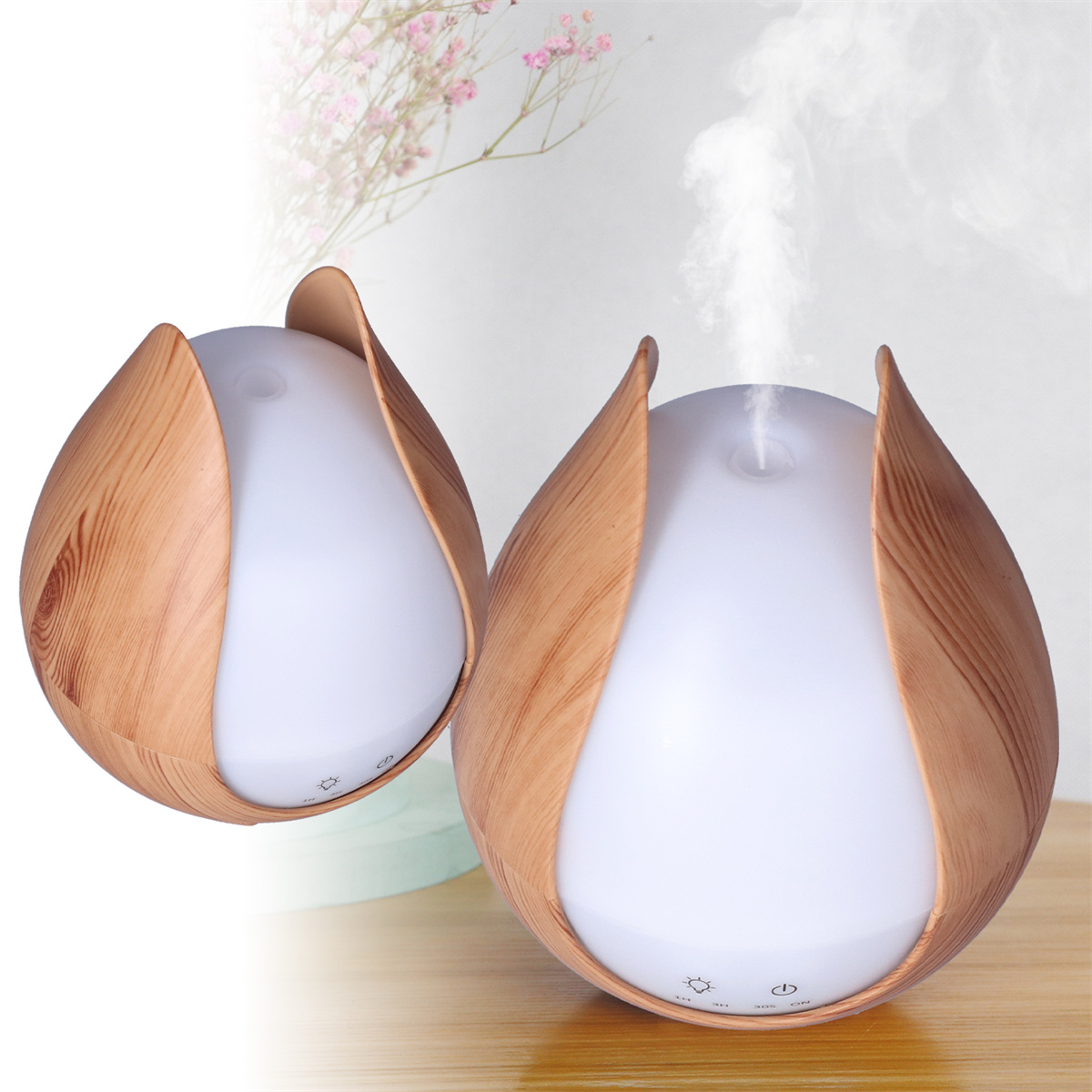 Zwei weiße und holzfarbene Aromadiffusoren. Sie sind tulpenförmig und geben Dampf ab.
