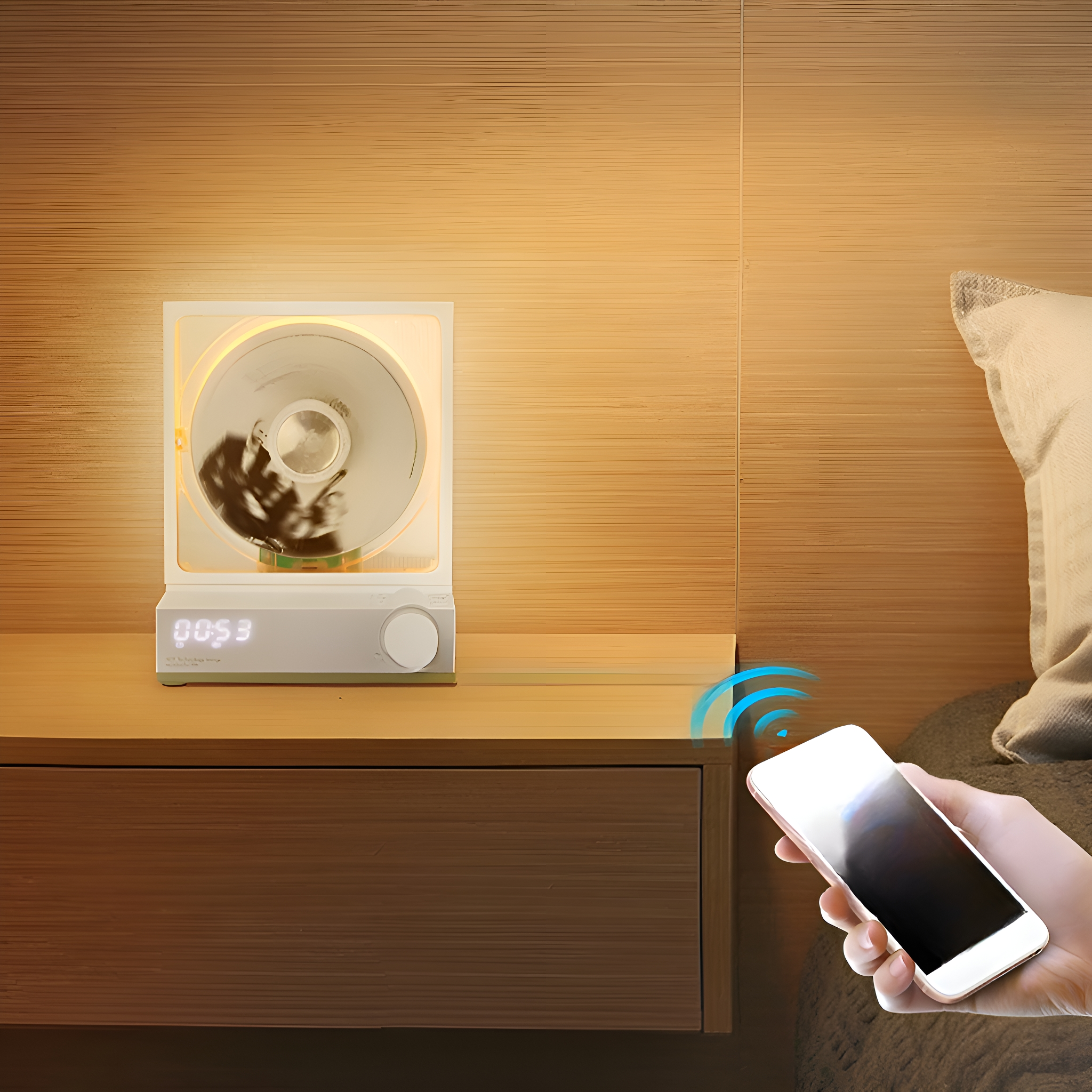 Ein Nachttisch mit einer Lampe, die Bilder zeigt, und einer Hand, die ein Telefon hält.