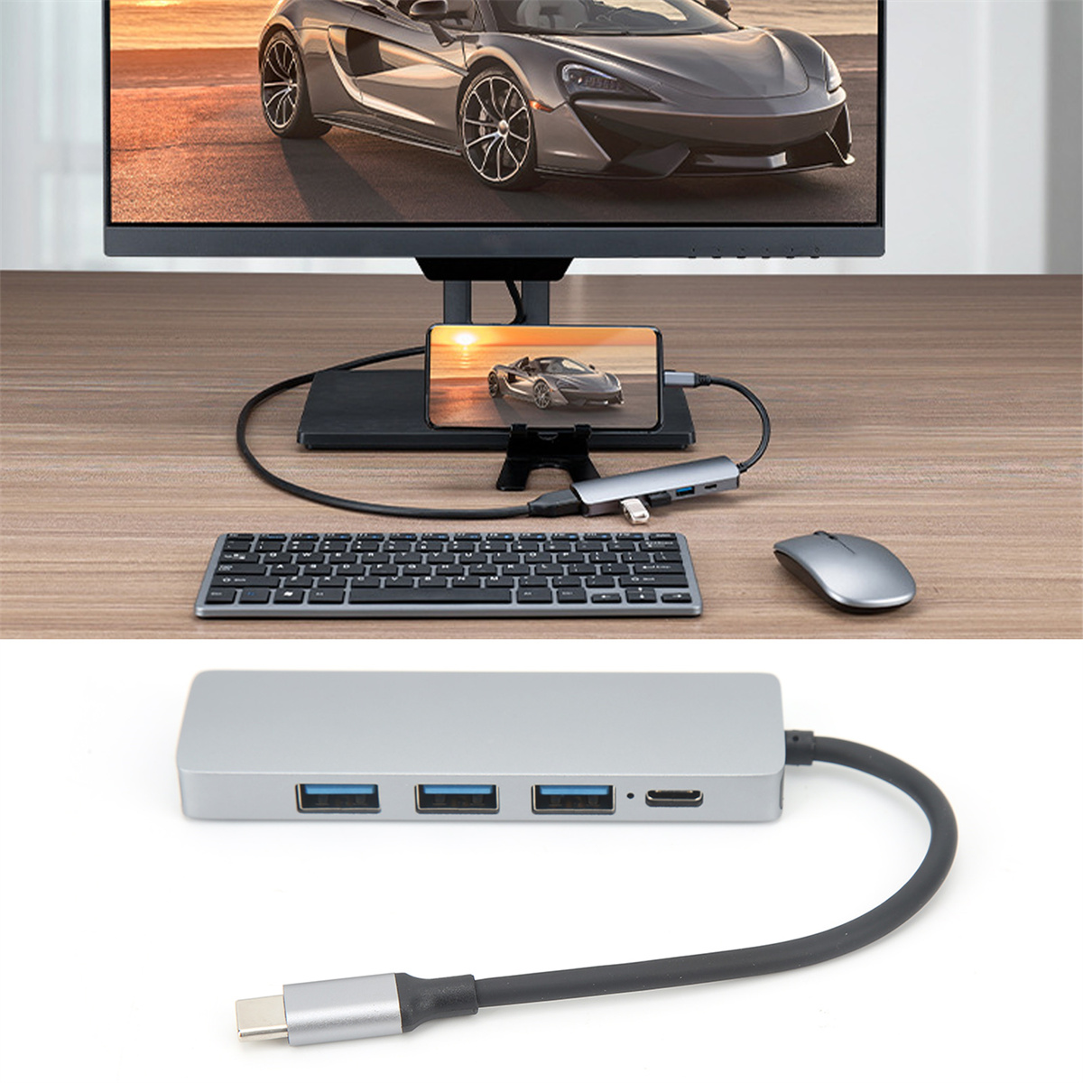 Ein Computer-Setup mit Hub, Telefon, Tastatur, Maus und Auto-Bild auf dem Bildschirm.