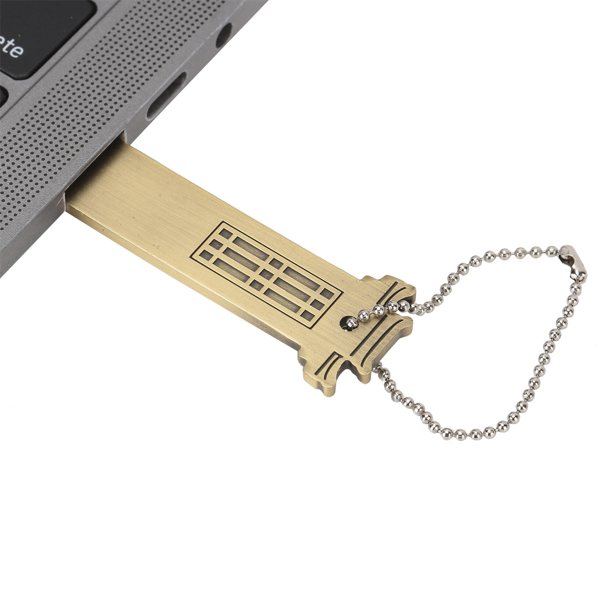 Ein goldfarbener USB-Stick steckt in einem Laptop. Es hat ein dekoratives Design auf der Vorderseite.