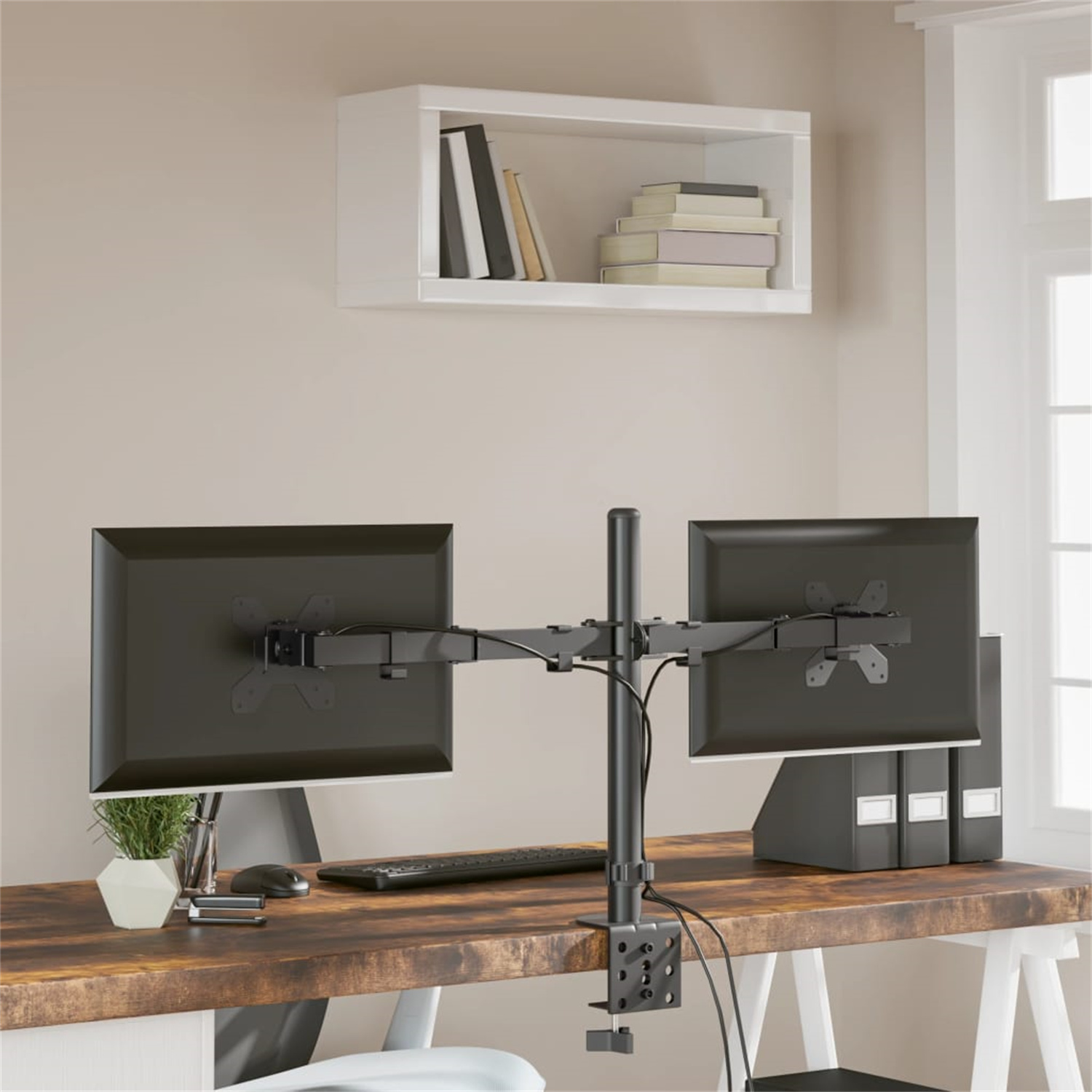 Zwei Computermonitore auf einem Schreibtisch mit Monitorarm. Tastatur, Maus und Bücher auf einem Regal.