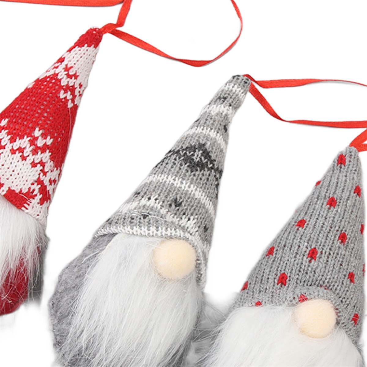Drei Weihnachtswichtel mit gestrickten Mützen und weißen Bärten, rote Bänder an den Mützen befestigt.