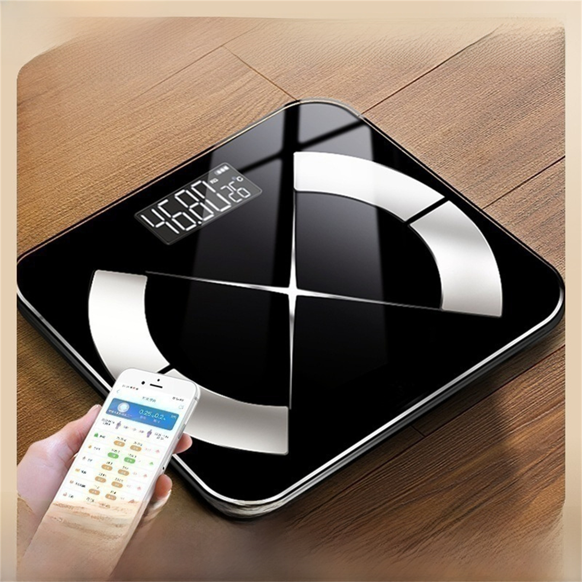 Schwarze Smart-Waage mit Digitalanzeige und weißem Smartphone.