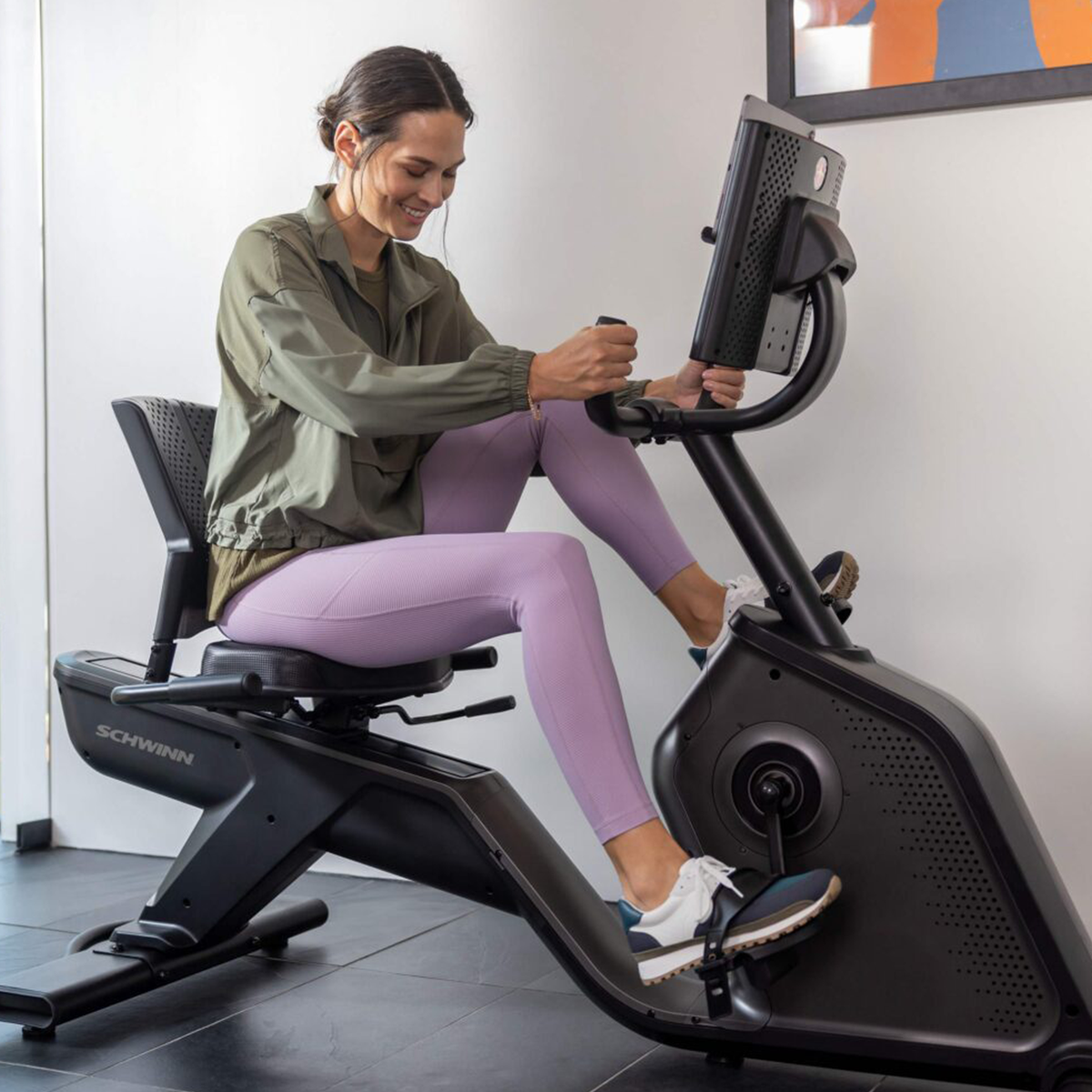 Eine Frau auf einem Heimtrainer, die in einem hellen Raum trainiert.
